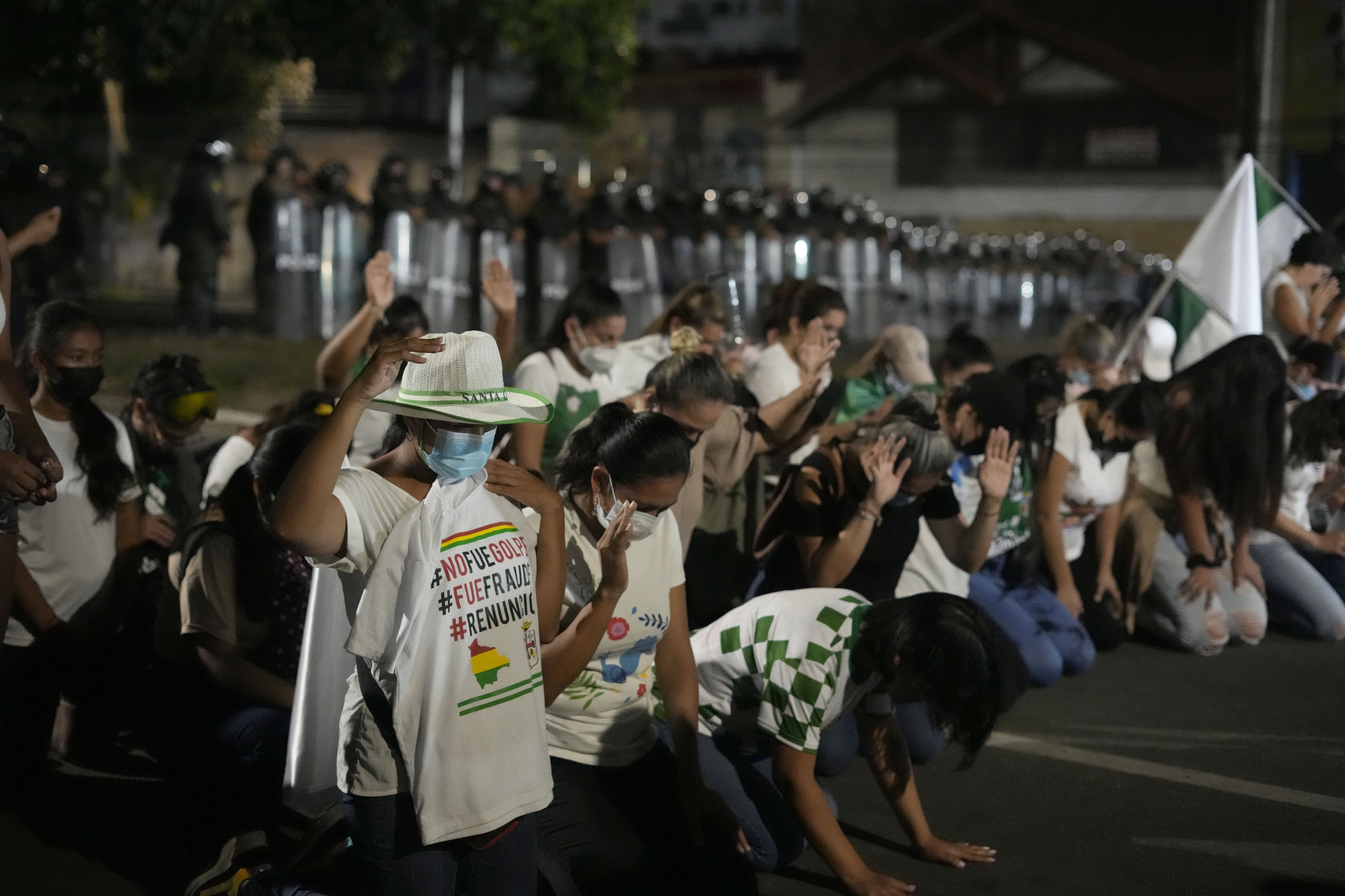 Seguidores del líder opositor y gobernador de Santa Cruz Luis Fernando Camacho se arrodillan durante una protesta en una barricada en Santa Cruz, Bolivia, el 3 de enero de 2023. Dirigentes de movimientos cívicos de oposición convocan el miércoles 25 de enero de 2023 a un cabildo nacional, una suerte de reunión de las bases, para decidir si retoman las protestas.(AP Foto/Juan Karita)