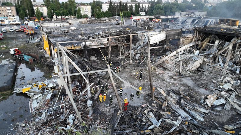 Rescatistas trabajan en el sitio de un centro comercial golpeado por un ataque de misiles rusos en Kremenchuk