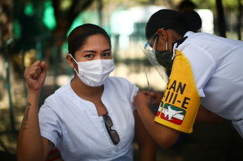 Una miembro del personal médico hace un gesto mientras recibe la primera inyección de la vacuna contra COVID-19 de Pfizer/BioNtech, en Ciudad de México, México, el 27 de diciembre de 2020. REUTERS/Edgard Garrido