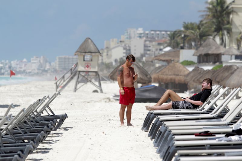 Los turistas estadounidenses se relajan en una playa después de las autoridades locales impusieron estrictas medidas sanitarias para reabrir gradualmente a pesar de la pandemia de la enfermedad por coronavirus (COVID-19), en Cancún, México, el 11 de junio de 2020. Foto: Reuters.