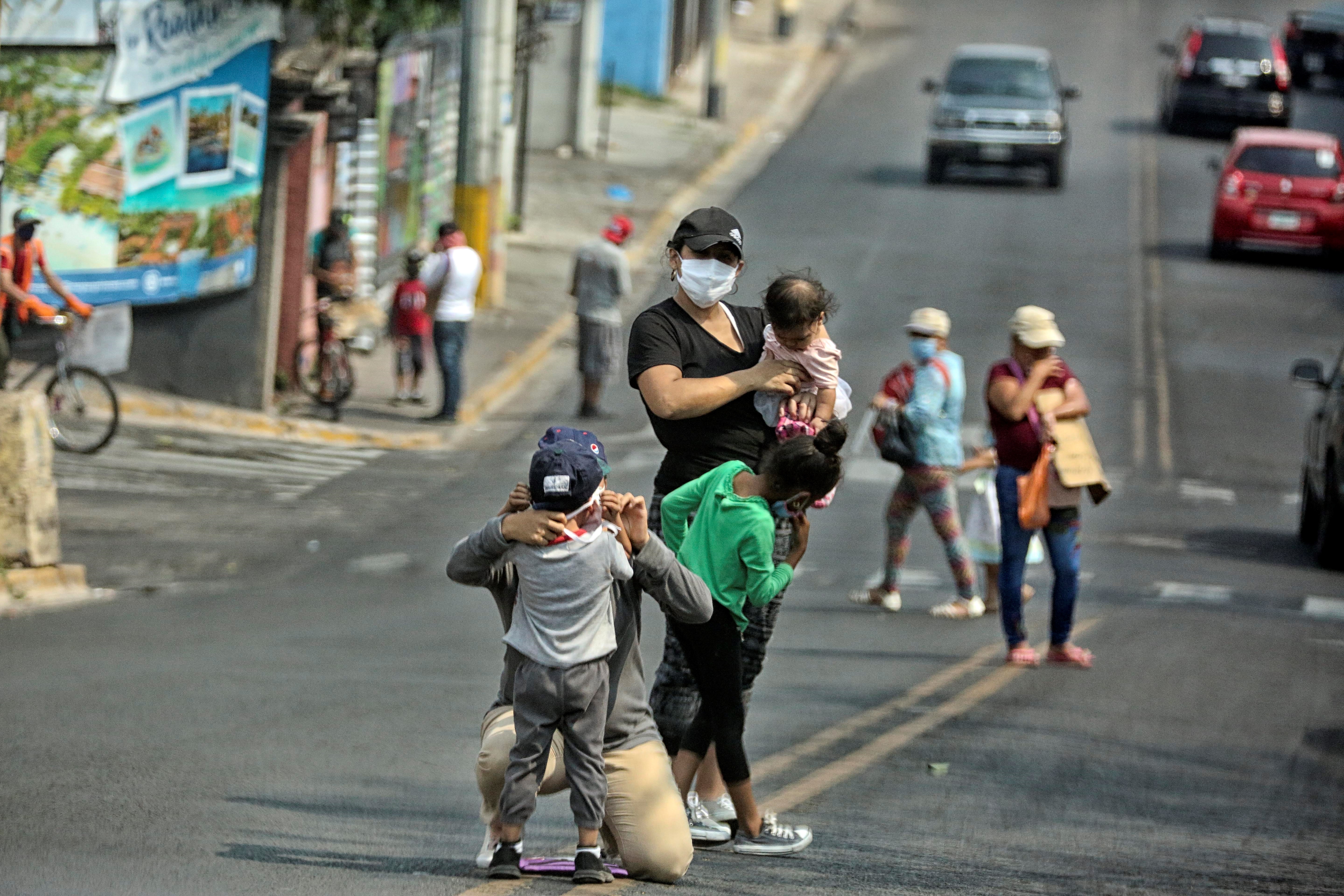 Una familia pide ayuda económica para comprar alimentos en una calle de Tegucigalpa. EFE/Gustavo Amador/Archivo

