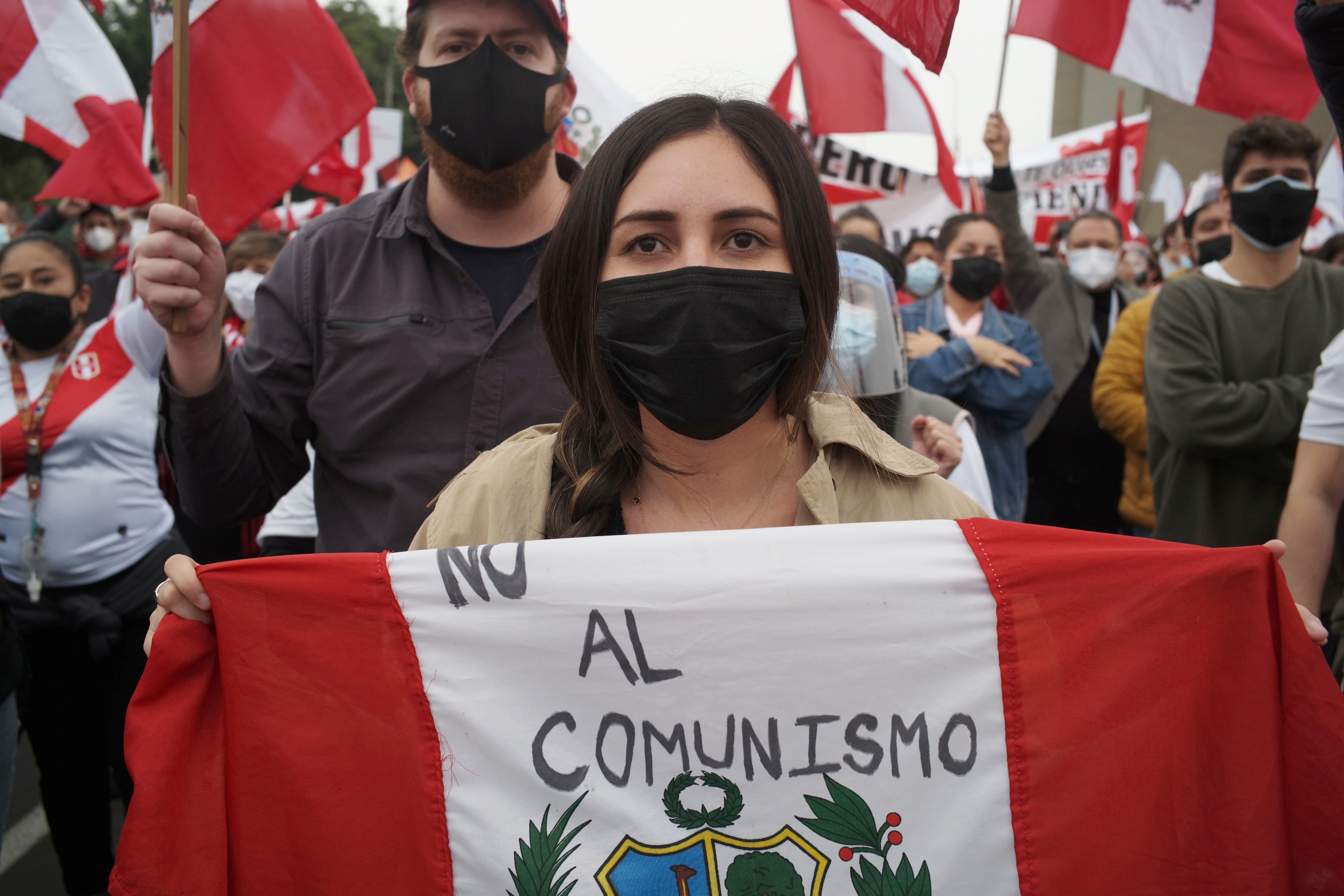 Simpatizante de Keiko Fujimori muestra una bandera peruana con la frase "no al comunismo"