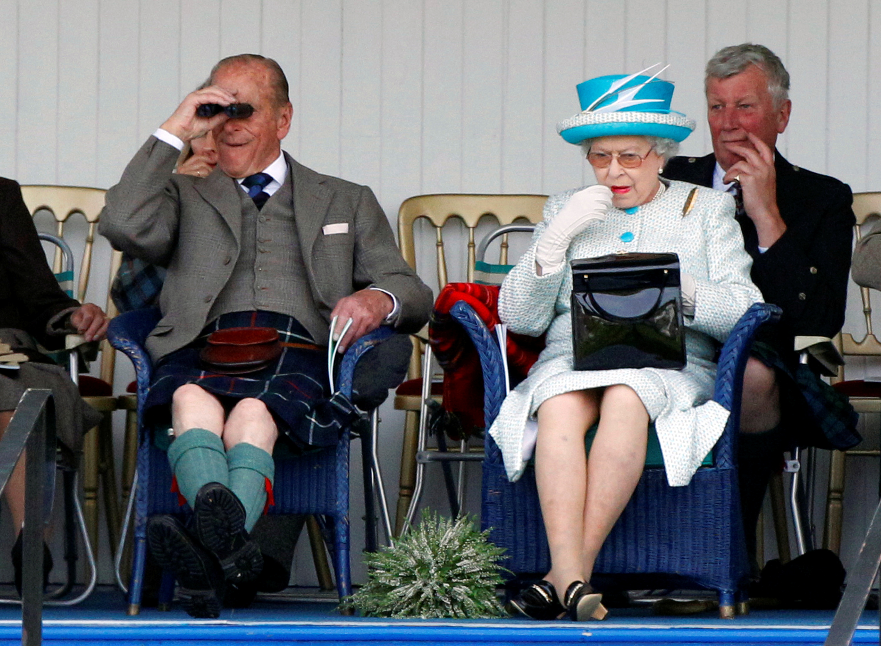 La reina Isabel de Gran Bretaña se aplica lápiz labial. A su lado está su esposo, el príncipe Felipe. La imagen fue tomada durante un evento en Escocia el 3 de septiembre de 2011