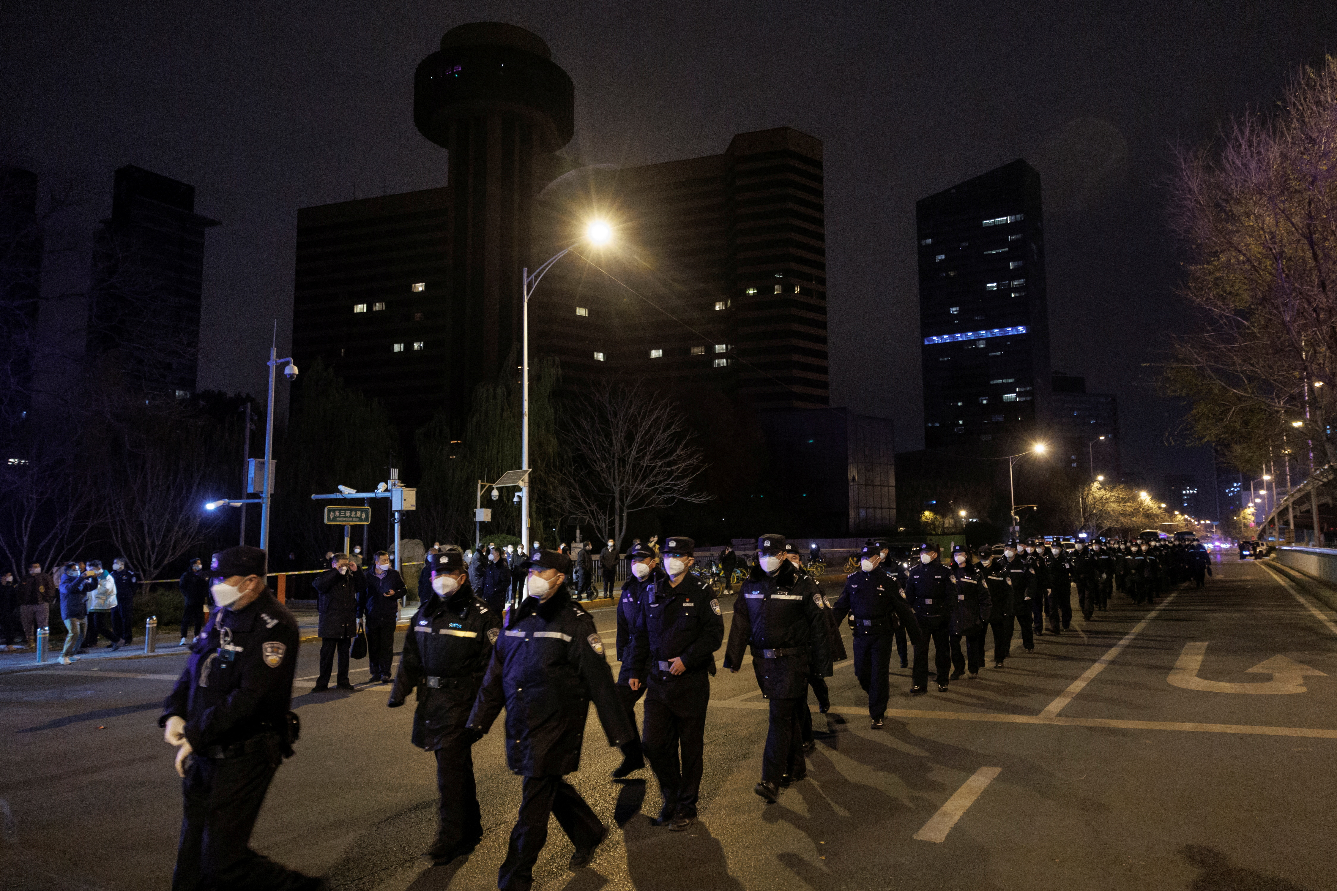 La policía llega a una protesta contra las restricciones de la enfermedad por coronavirus (COVID-19) después de una vigilia por las víctimas de un incendio en Urumqi, mientras continúan los brotes de COVID-19, en Beijing, China REUTERS/Thomas Peter