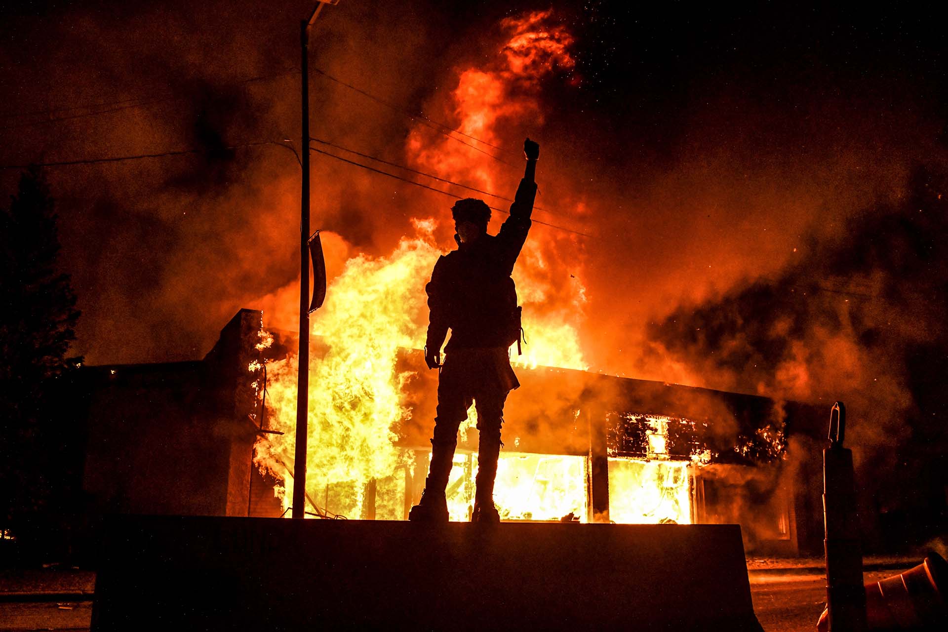 Un manifestante frente a un edificio incendiado durante una manifestación en Minneapolis, Minnesota, el 29 de mayo de 2020 (Foto de Chandan KHANNA / AFP)