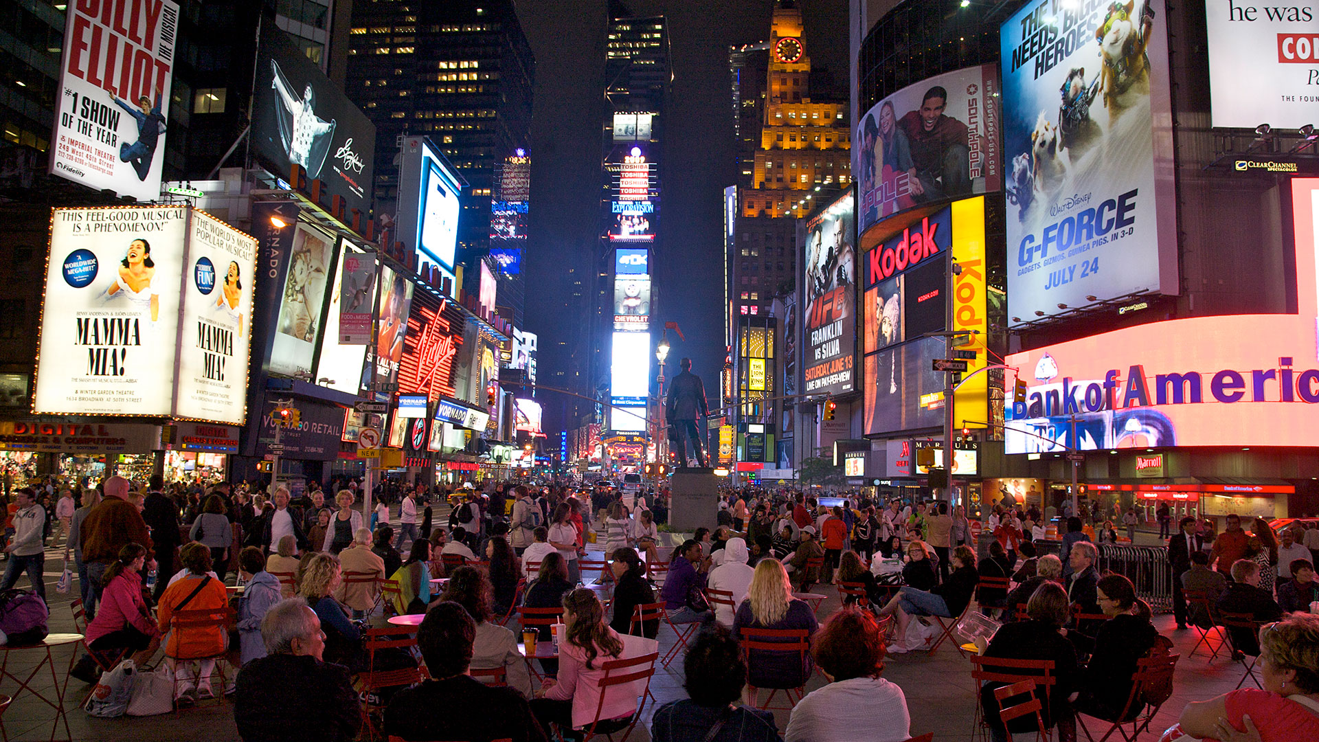 Multitud en Duffy Square, mirando hacia Times Square de noche, en la ciudad de Nueva York