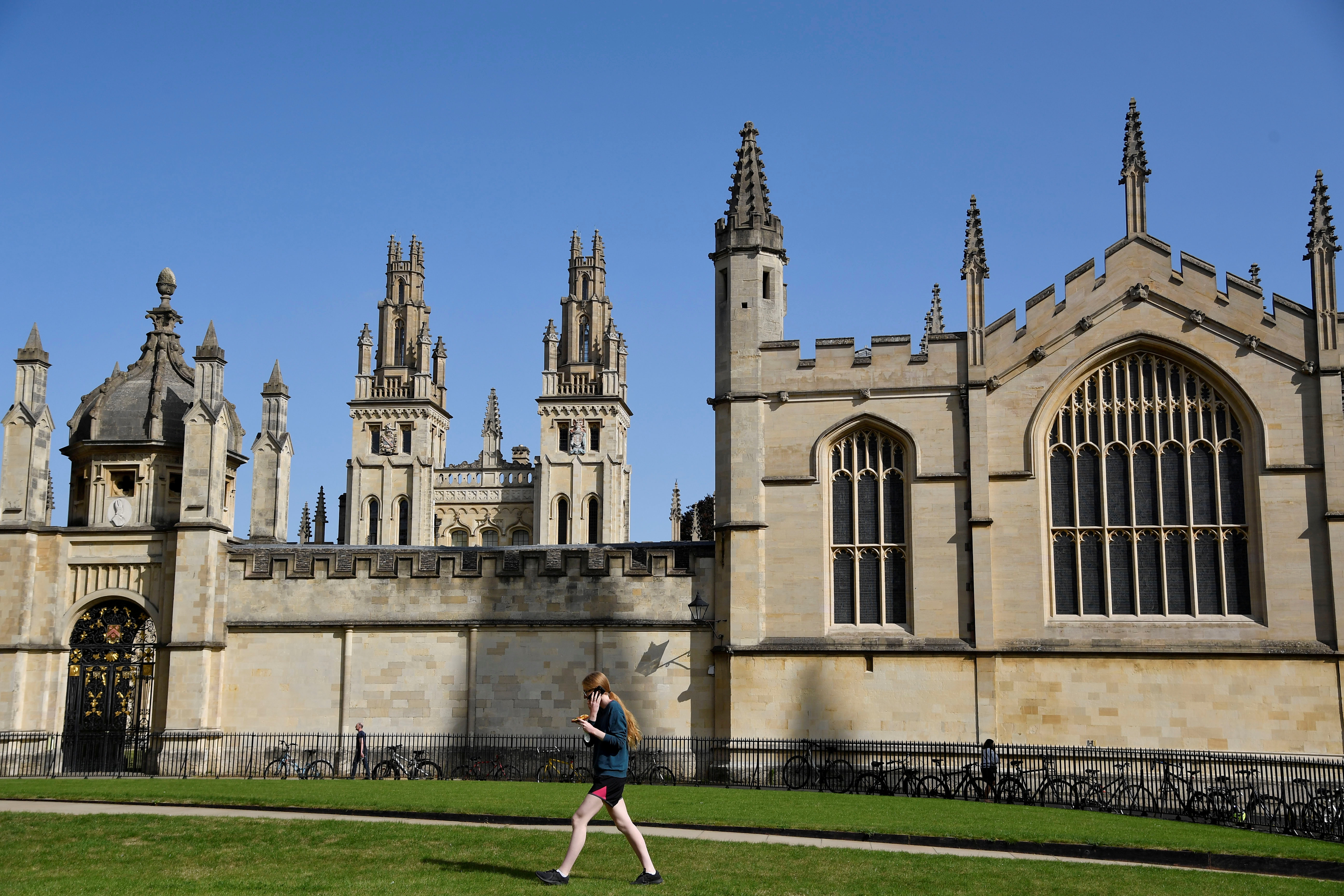 Un estudiante camina por un césped frente al All Souls College de la Universidad de Oxford, antes del nuevo año académico (REUTERS/Toby Melville/Foto de archivo)
