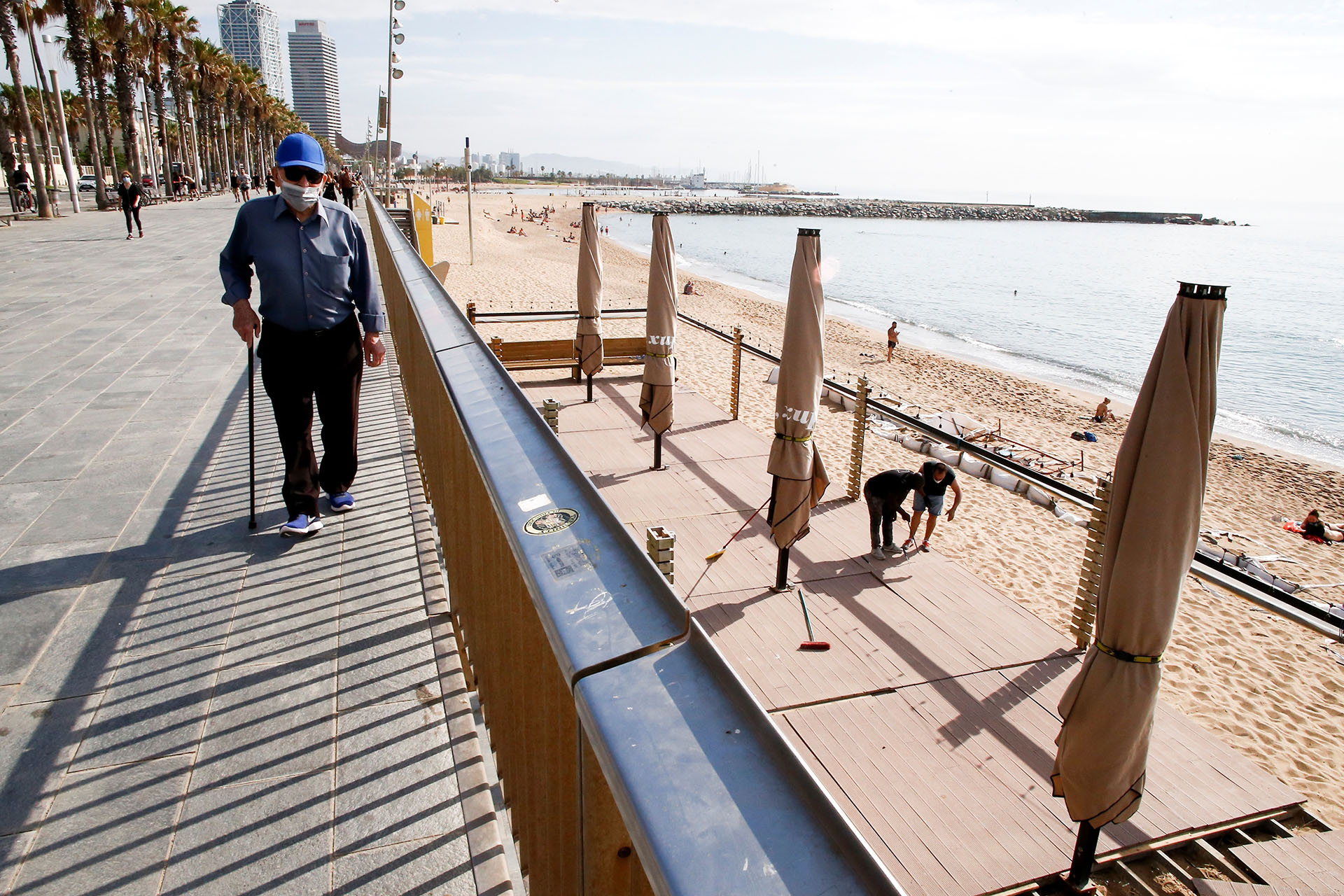 Varios trabajadores de un chiringuito de la playa de la Barceloneta preparan el local, este lunes en Barcelona que ha entrado en la Fase 1 de la descalada. (EFE/ Quique García)