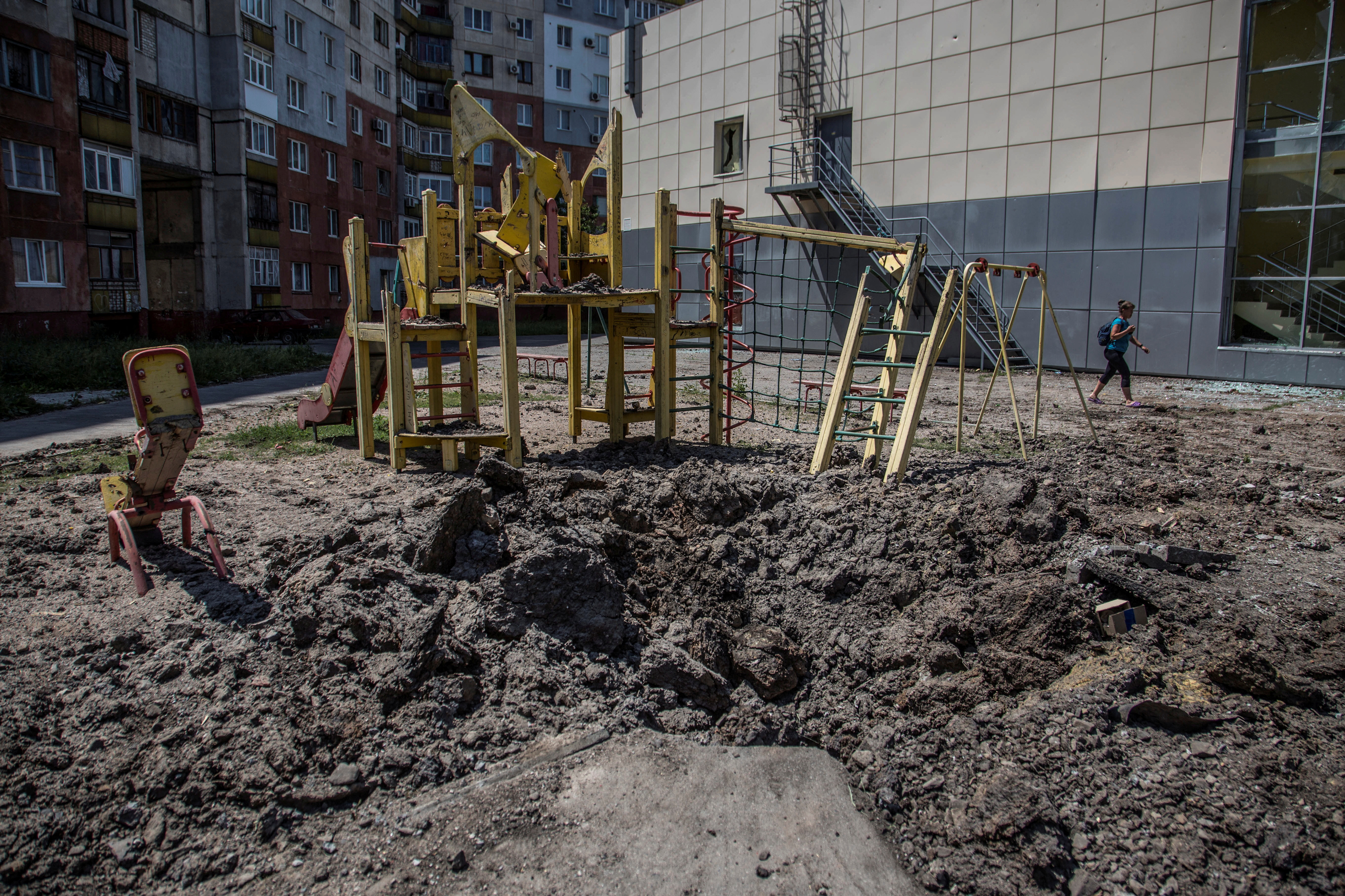 Una lugareña pasa junto a un parque infantil, dañado durante los bombardeos rusos, en la ciudad de Lisychansk, región de Lugansk (REUTERS/Oleksandr Ratushniak)