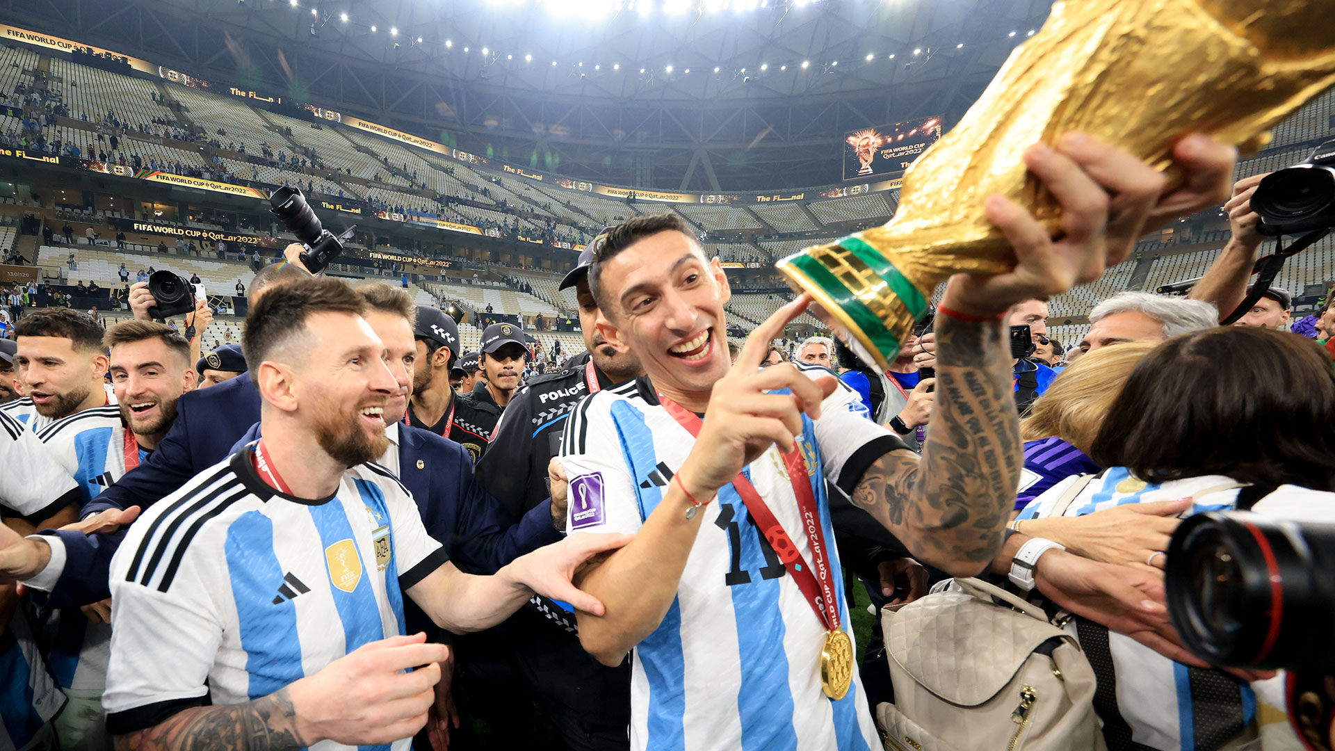 LUSAIL CITY, QATAR - DECEMBER 18: Lionel Messi and Ángel Di María of Argentina hold the FIFA World Cup Qatar 2022 Winner's Trophy after winning the FIFA World Cup Qatar 2022 Final match between Argentina and France at Lusail Stadium on December 18, 2022 in Lusail City, Qatar. (Photo by Gustavo Pagano/Getty Images)