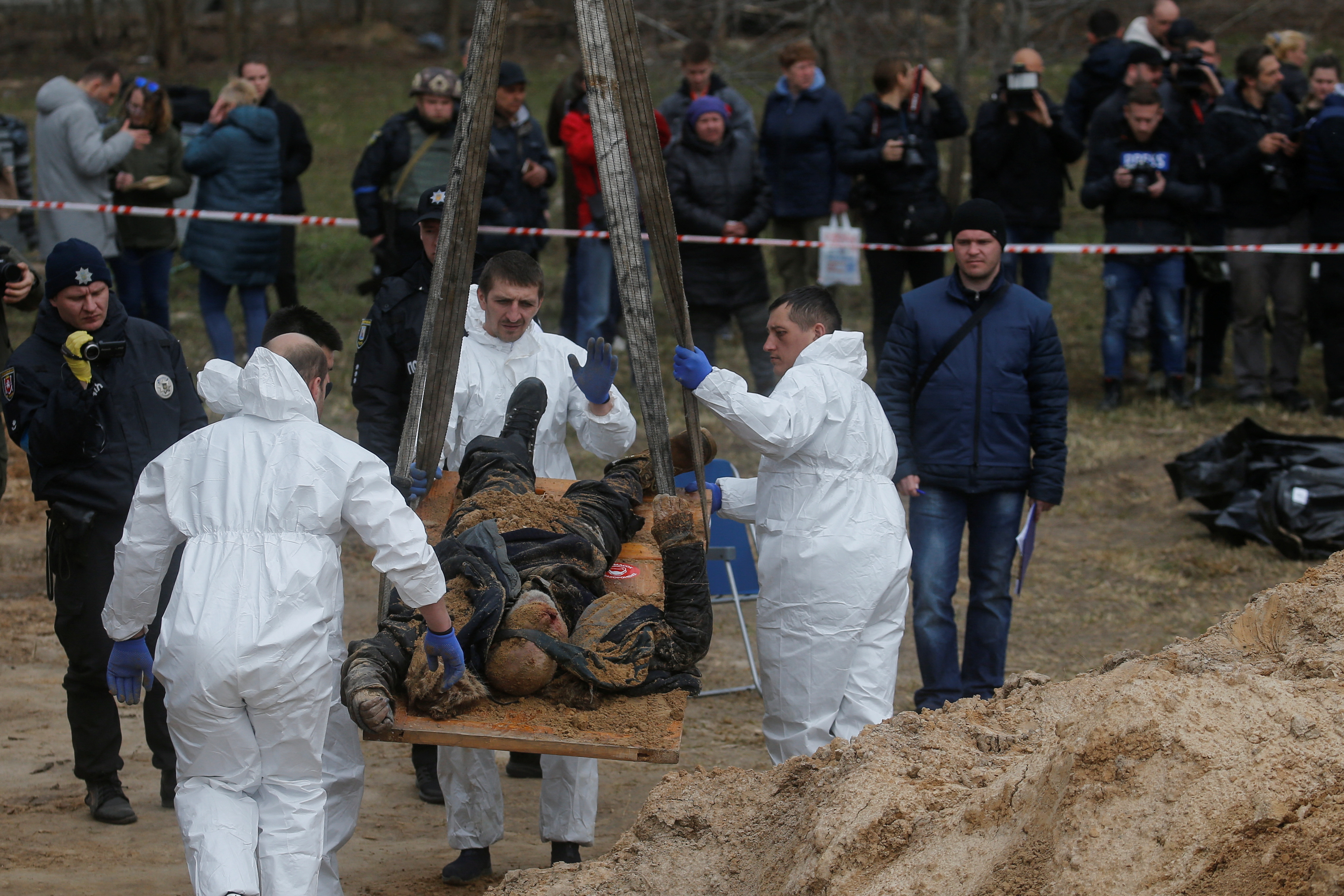 Técnicos forenses exhuman el cuerpo de un civil que, según las autoridades ucranianas, murió durante la invasión rusa y luego fue enterrado en una fosa común en la ciudad de Bucha, en las afueras de Kiev, Ucrania, el 8 de abril de 2022. REUTERS/Valentyn Ogirenko