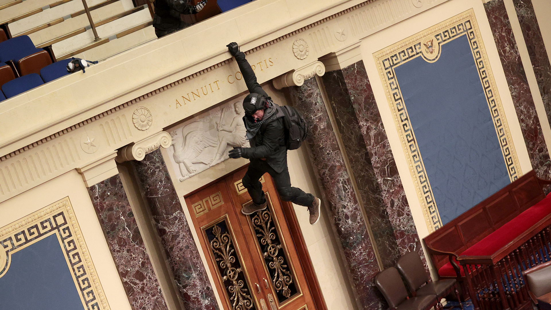 Un manifestante se cuelga del balcón de la Cámara del Senado (Win McNamee/Getty Images/AFP)