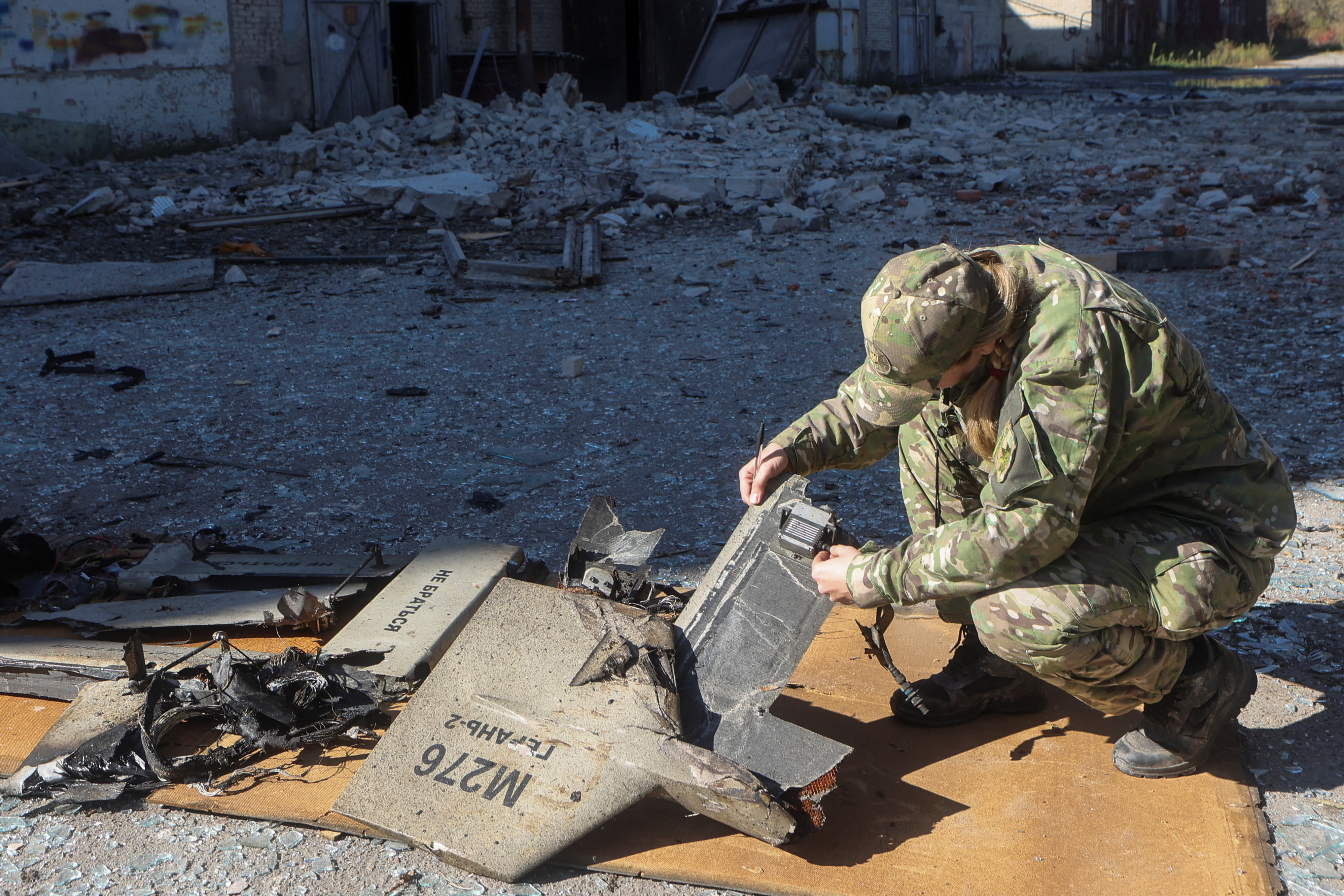 Un oficial de policía inspecciona partes un drone suicida Shahed-136 de fabricación iraní, en un lugar de un ataque ruso contra instalaciones de almacenamiento de combustible, en Kharkiv, Ucrania 6 de octubre de 2022 (REUTERS)