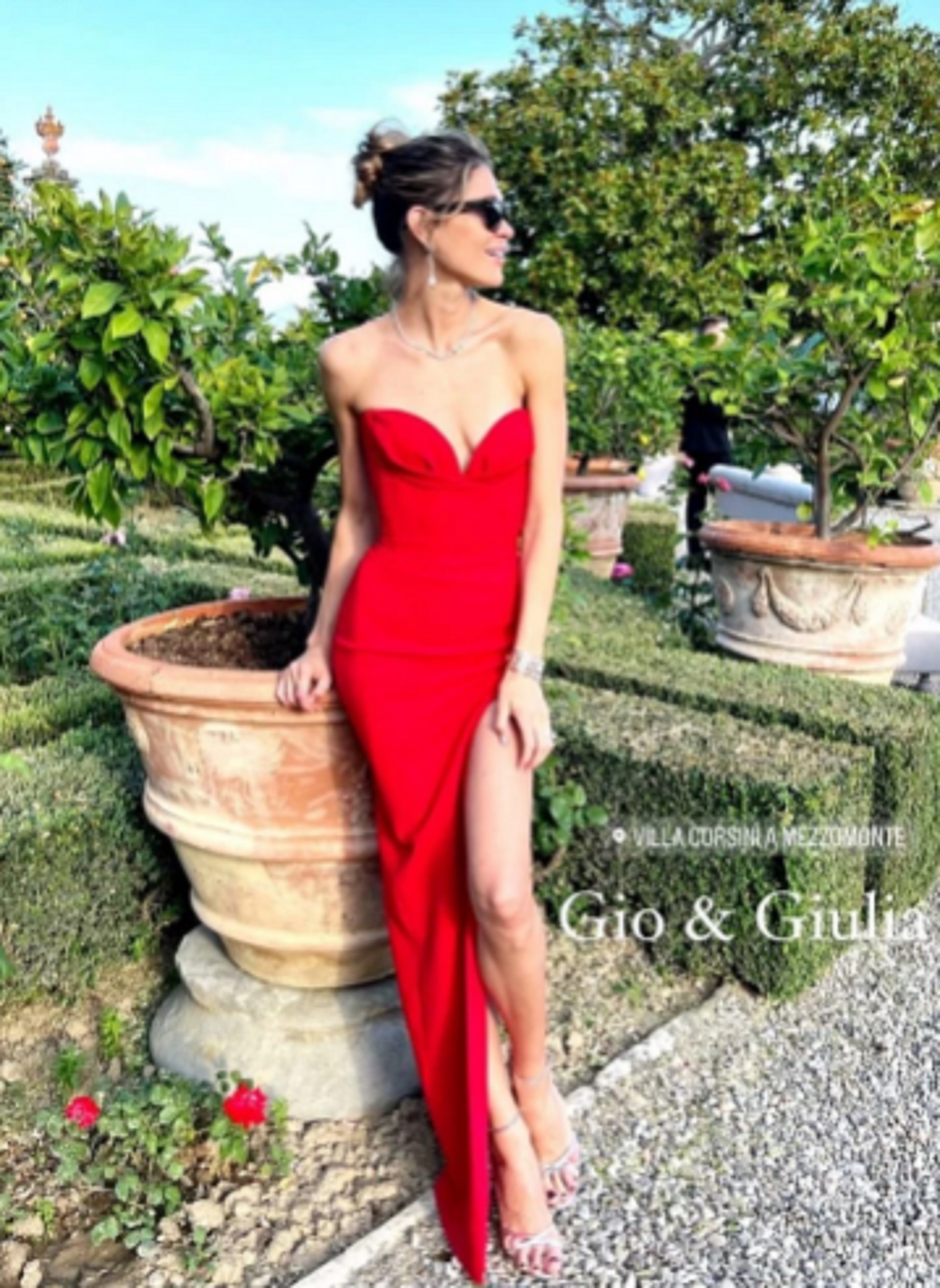 Carla Pereyra lució un vestido rojo con strapless con escote corazón, un tajo y sandalias plateadas. Además, llevó el pelo recogido y lentes de sol
