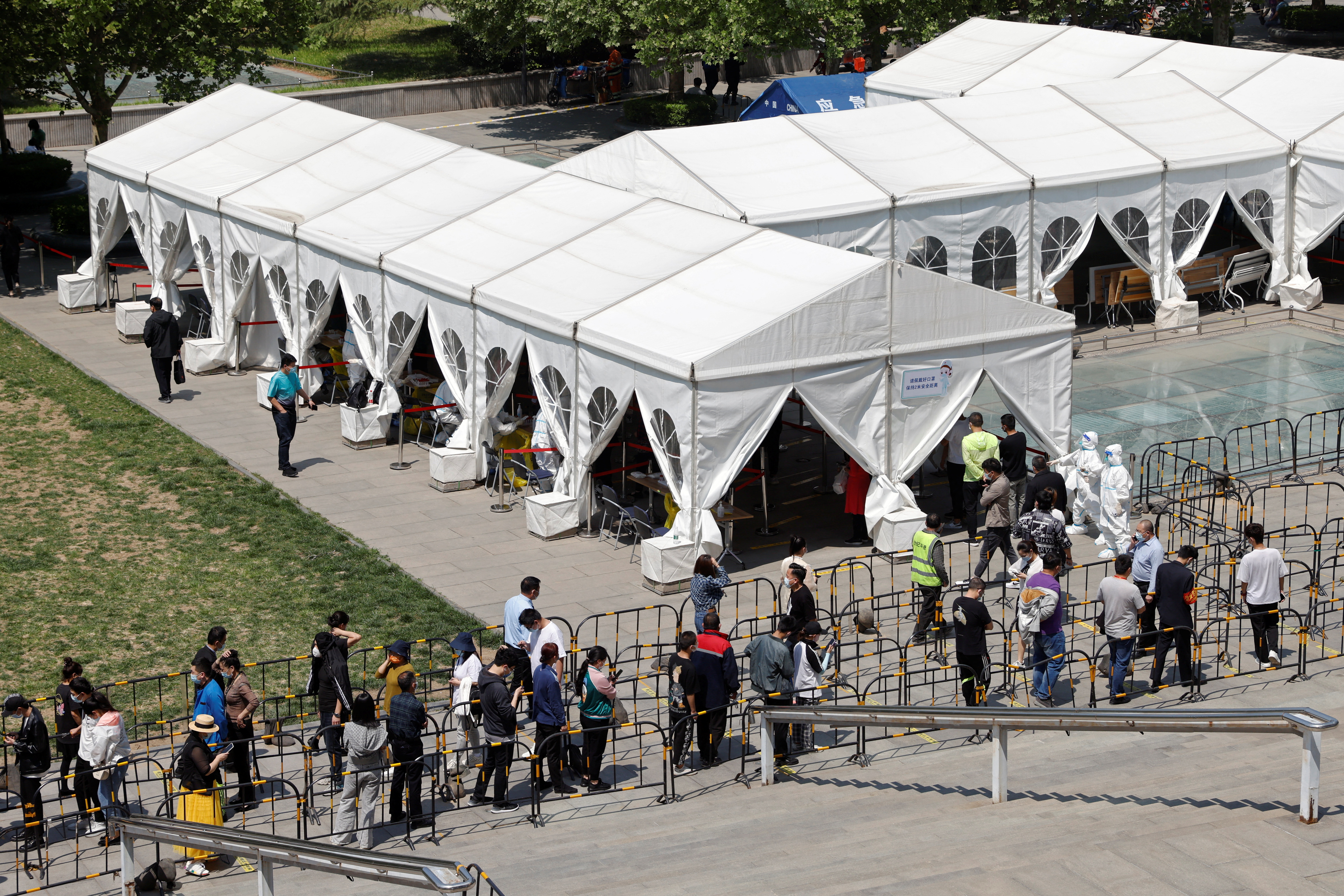 La gente se alinea fuera de un sitio de prueba de ácido nucleico improvisado durante una prueba masiva para la enfermedad del coronavirus (COVID-19) en el distrito de Haidian de Beijing, China, el 2 de mayo de 2022. REUTERS/Carlos García Rawlins
