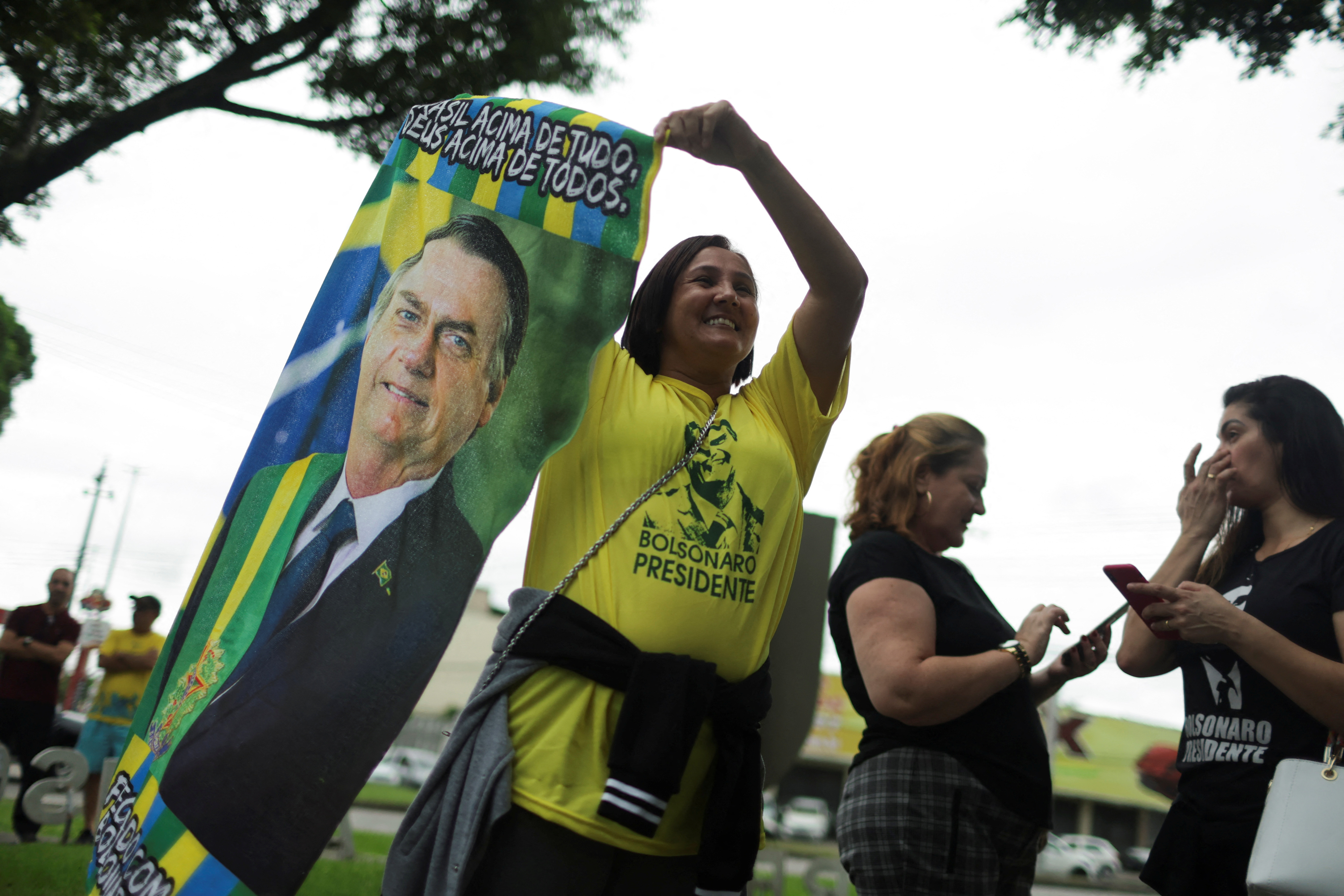 A supporter of Brazil's President and presidential candidate Jair Bolsonaro holds a banner with his picture during the presidential election, in Rio de Janeiro, Brazil October 2, 2022. REUTERS/Pilar Olivares