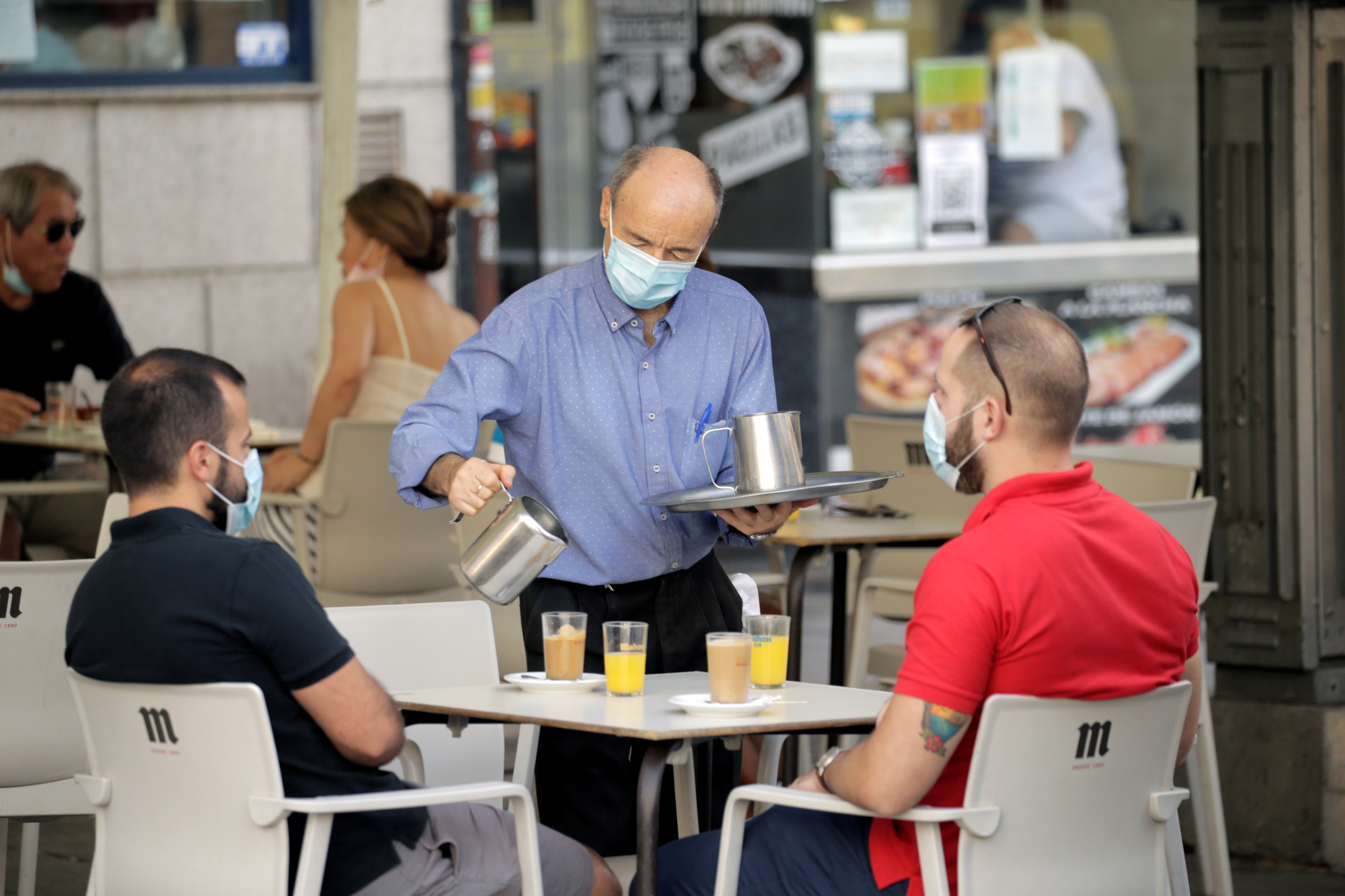 Un camarero sirve el desayuno en la terraza de un bar en la región de Madrid (REUTERS/Javier Barbancho)
