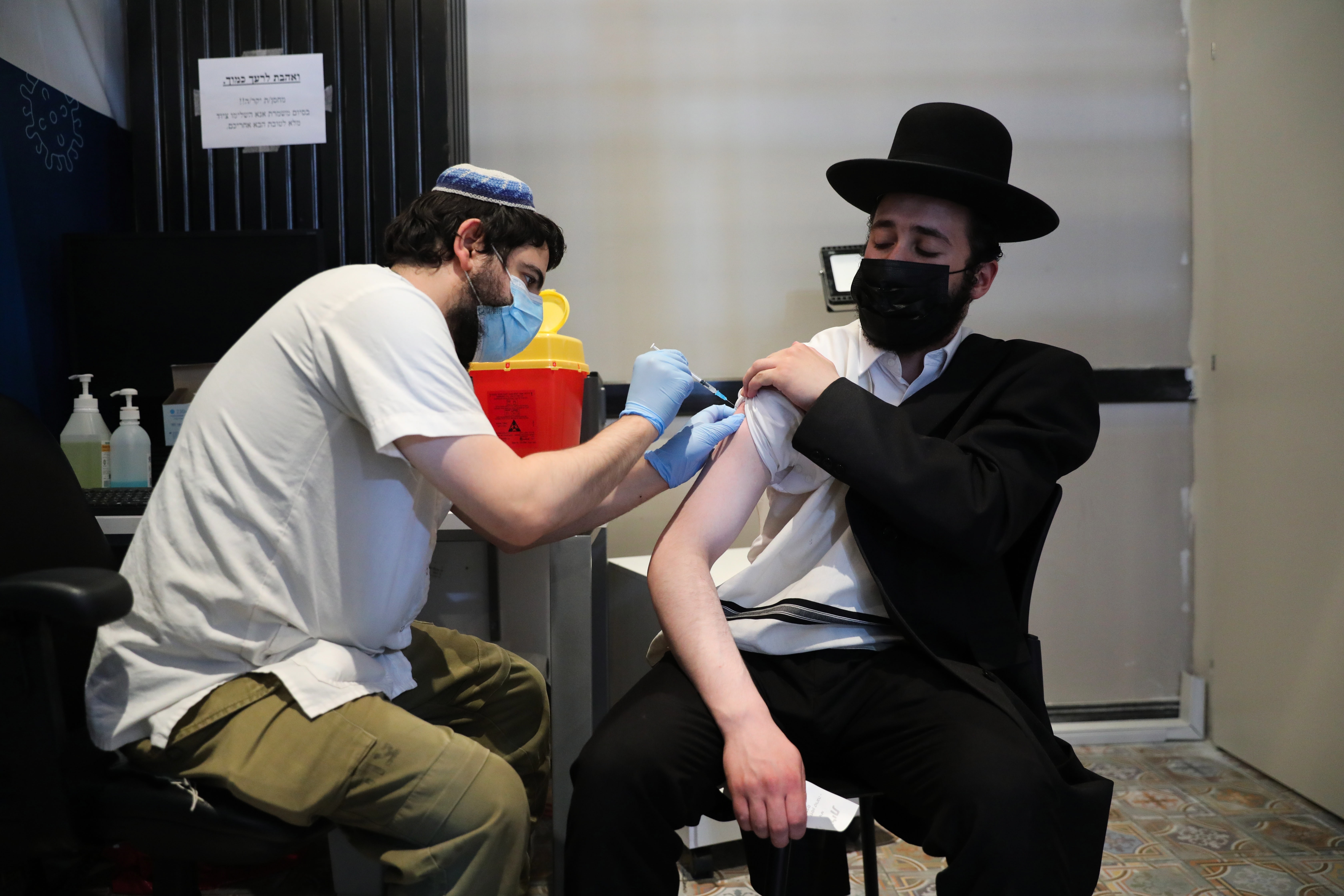 Un enfermero inyecta a un hombre ultraortodoxo una tercera inyección de la vacuna COVID-19 en Jerusalén, Israel. EFE/ABIR SULTAN
