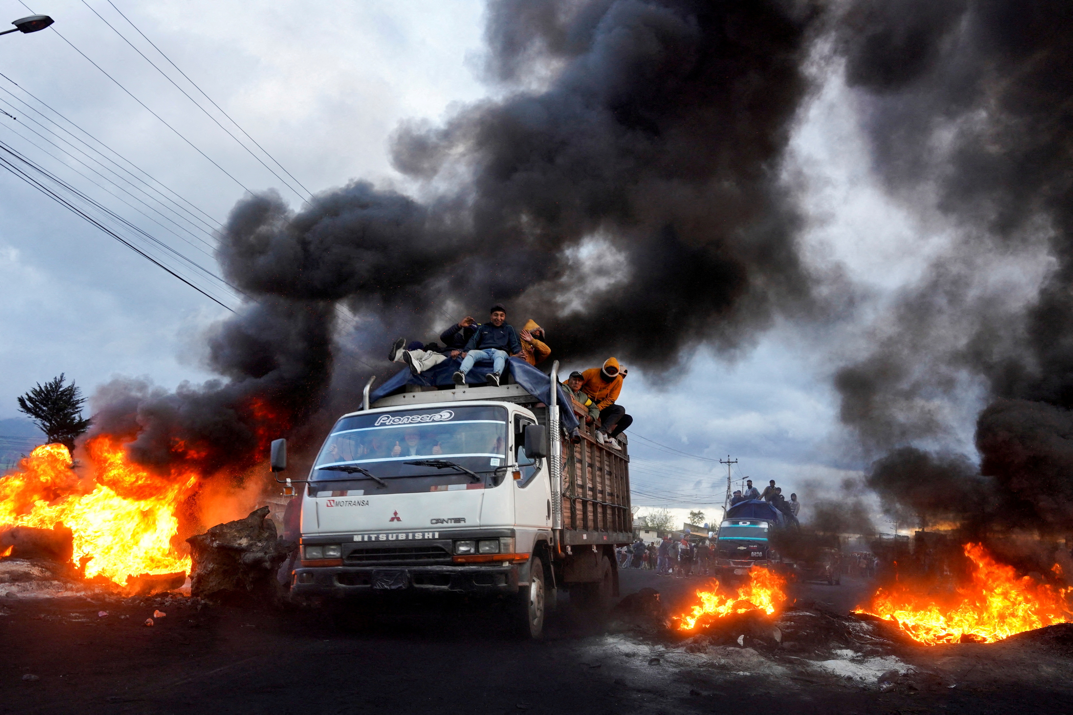 Manifestantes indígenas pasan por delante de bloqueos de carretera en llamas mientras se dirigen a la capital, Quito, tras una semana de protestas  (REUTERS/Johanna Alarcon)