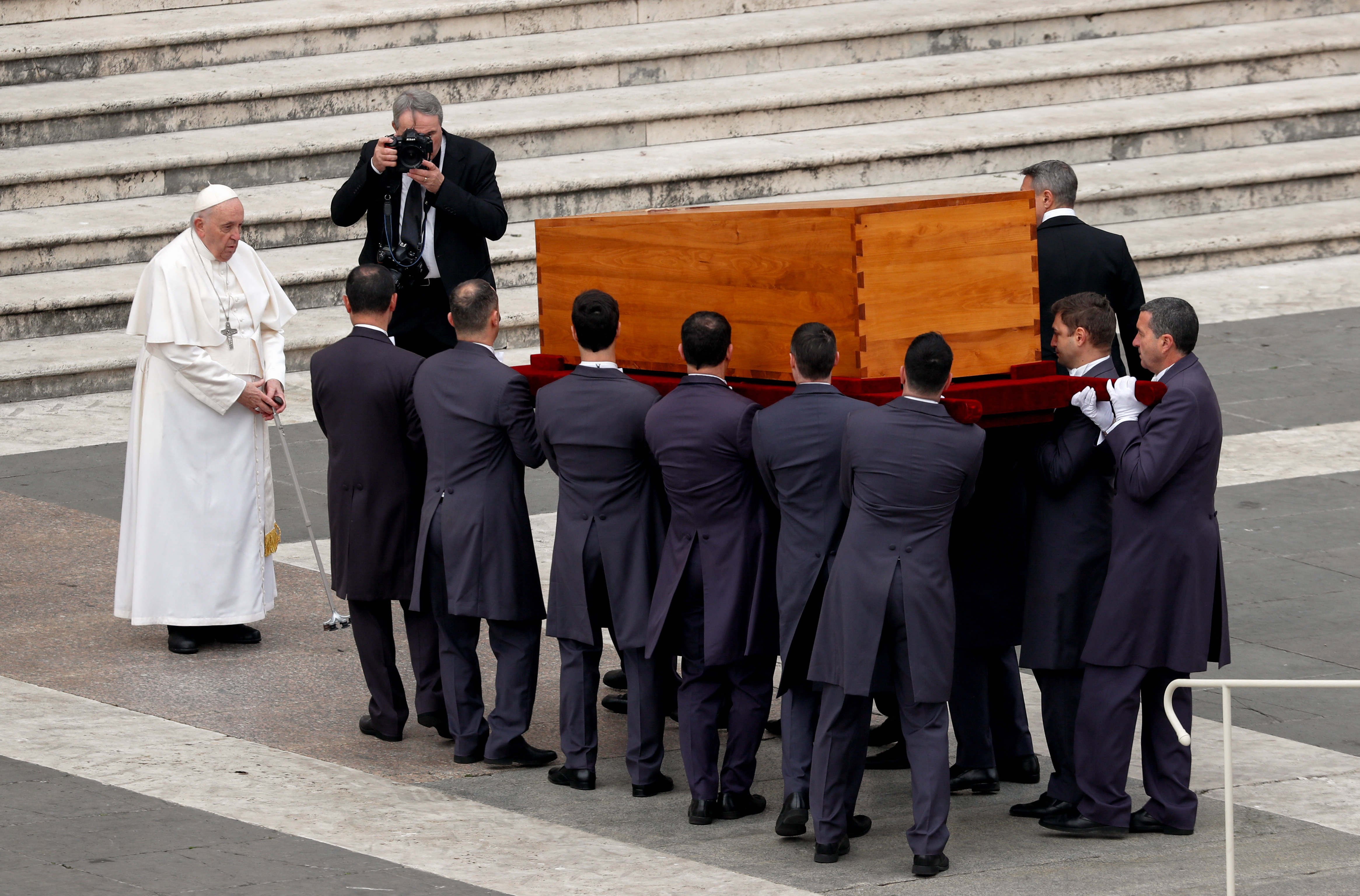El Papa Francisco se encuentra mientras los portadores del féretro llevan el ataúd del ex Papa Benedicto al final de su funeral.