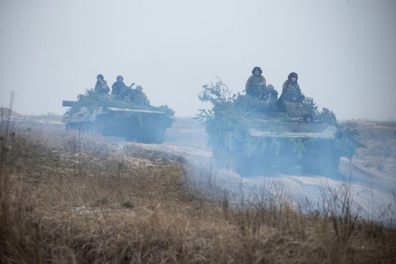 Miembros del servicio ucranianos viajan sobre vehículos de combate blindados durante ejercicios tácticos en un campo de entrenamiento en un lugar desconocido en Ucrania
