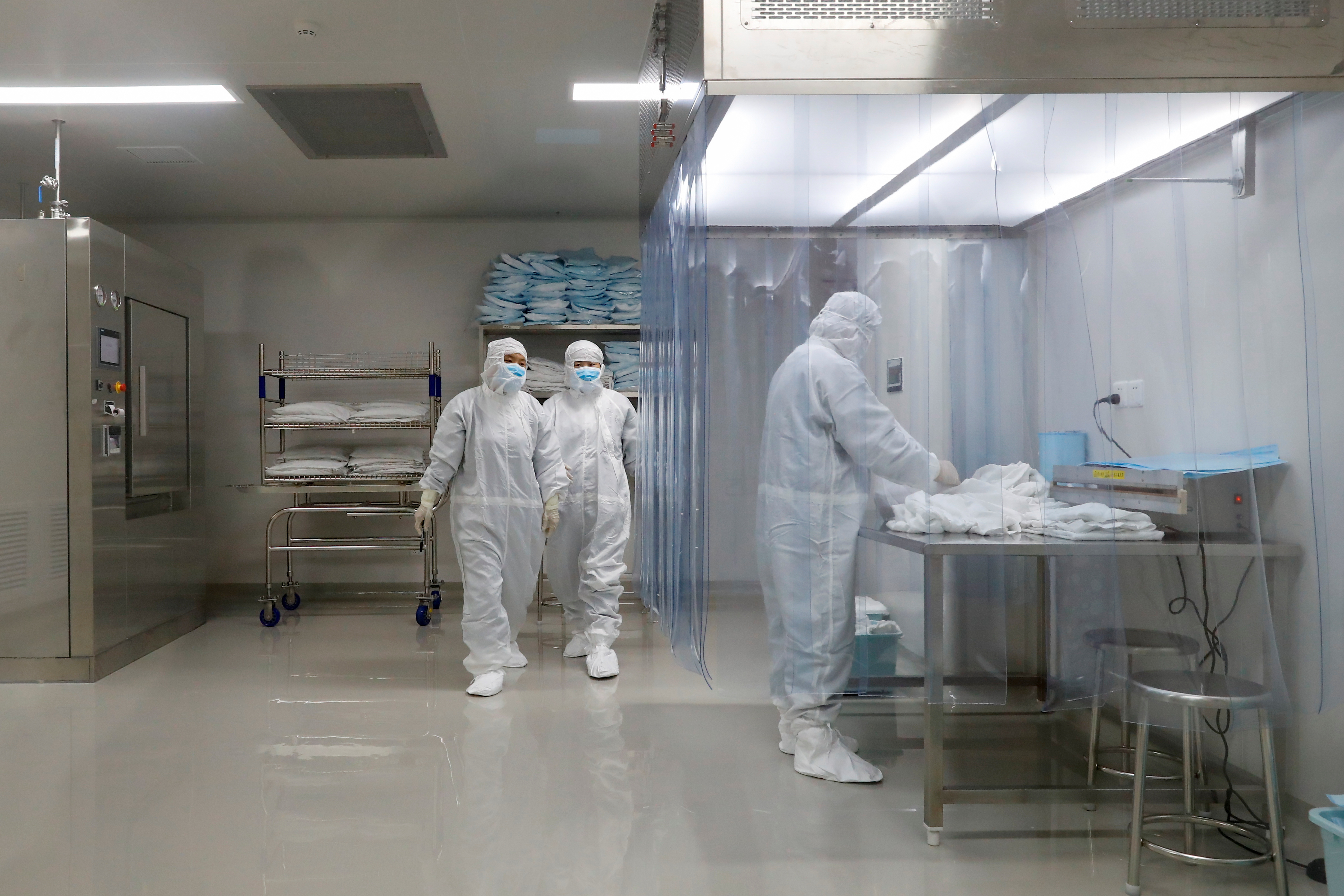 People work at a facility of Chinese vaccine maker Sinovac Biotech, that is developing an experimental coronavirus disease (COVID-19) vaccine, during a government-organized media tour in Beijing, China, September 24, 2020. Picture taken September 24, 2020.  REUTERS/Thomas Peter