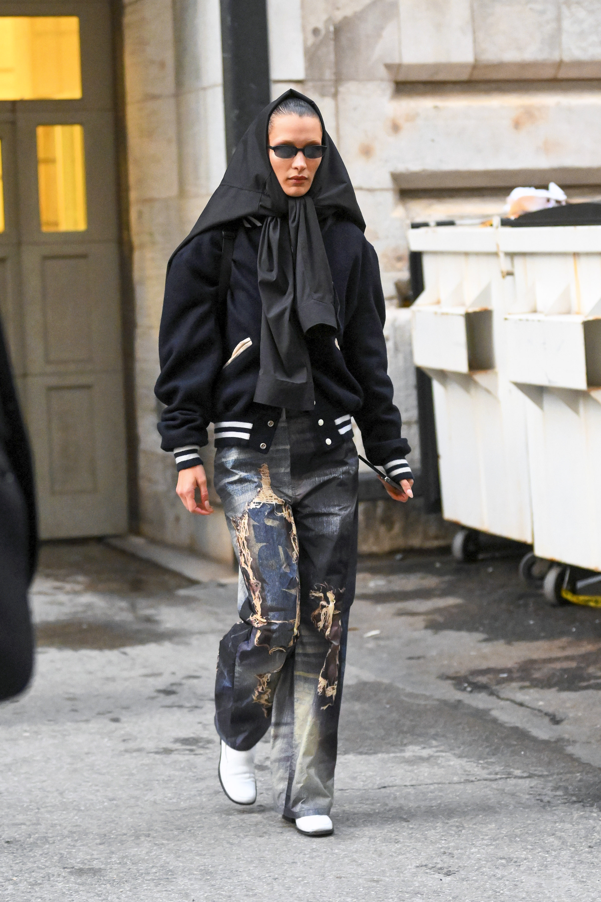 Bella Hadid wanted to avoid the photographers so as not to show her new look while leaving an exclusive fashion event: for this, she put a jacket over her hair.  She wore patterned jean pants and a black jacket.  Also, she wore sunglasses.