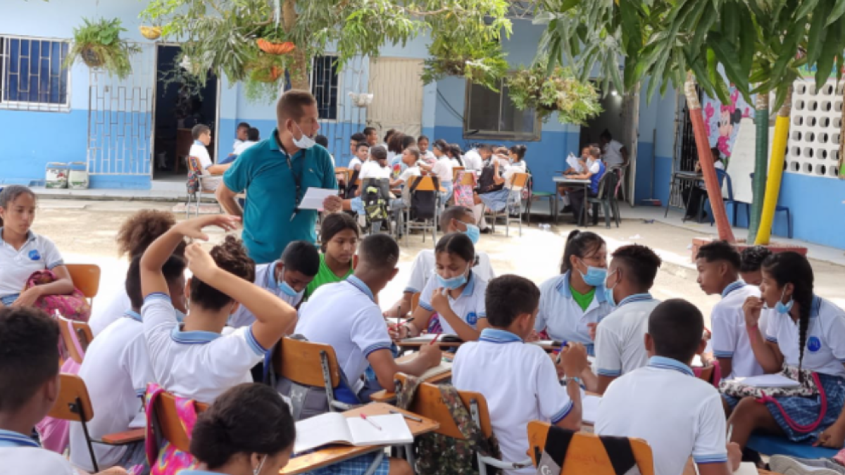 Imagen de cómo los estudiantes del colegio María Michelsen de Arjona reciben sus clases bajo dos árboles. Foto: archivo particular