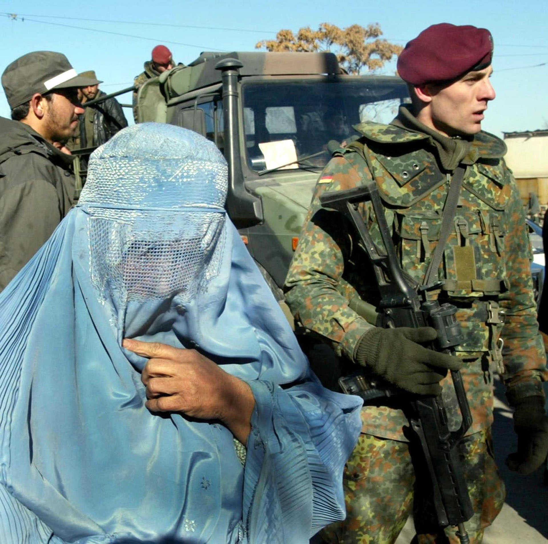 Fotografía de 19 de enero de 2002 de soldados alemanes patrullando en el centro de Kabul mientras pasa una mujer. (AFP/ EPA / ANJA NIEDRINGHAUS)