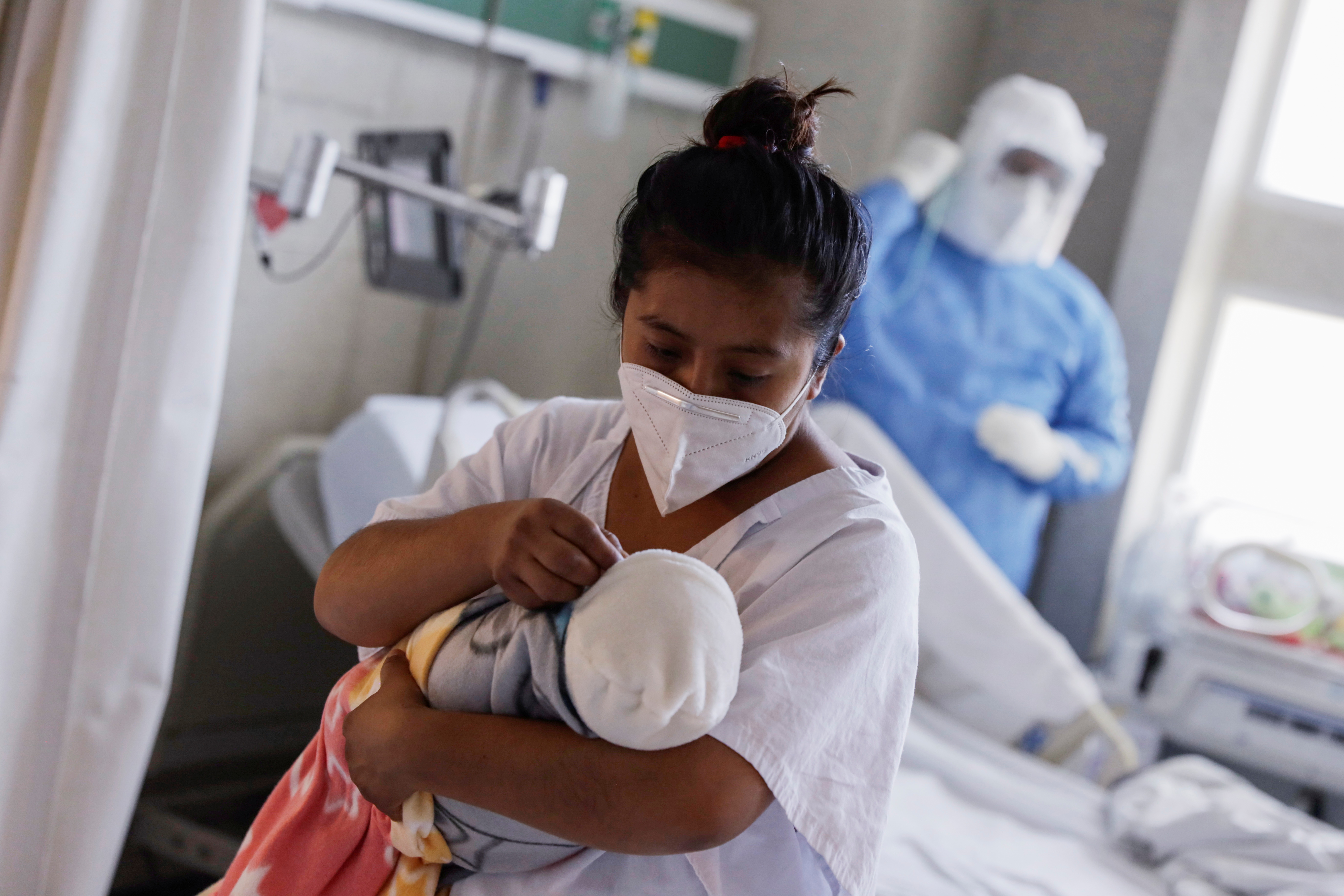 Una mujer infectada con COVID-19 carga a su bebé en la sala de maternidad del Hospital Materno Perinatal 'Mónica Pretelini Sáenz', en Toluca, México, el 4 de febrero de 2021 (REUTERS/Luis Cortes)