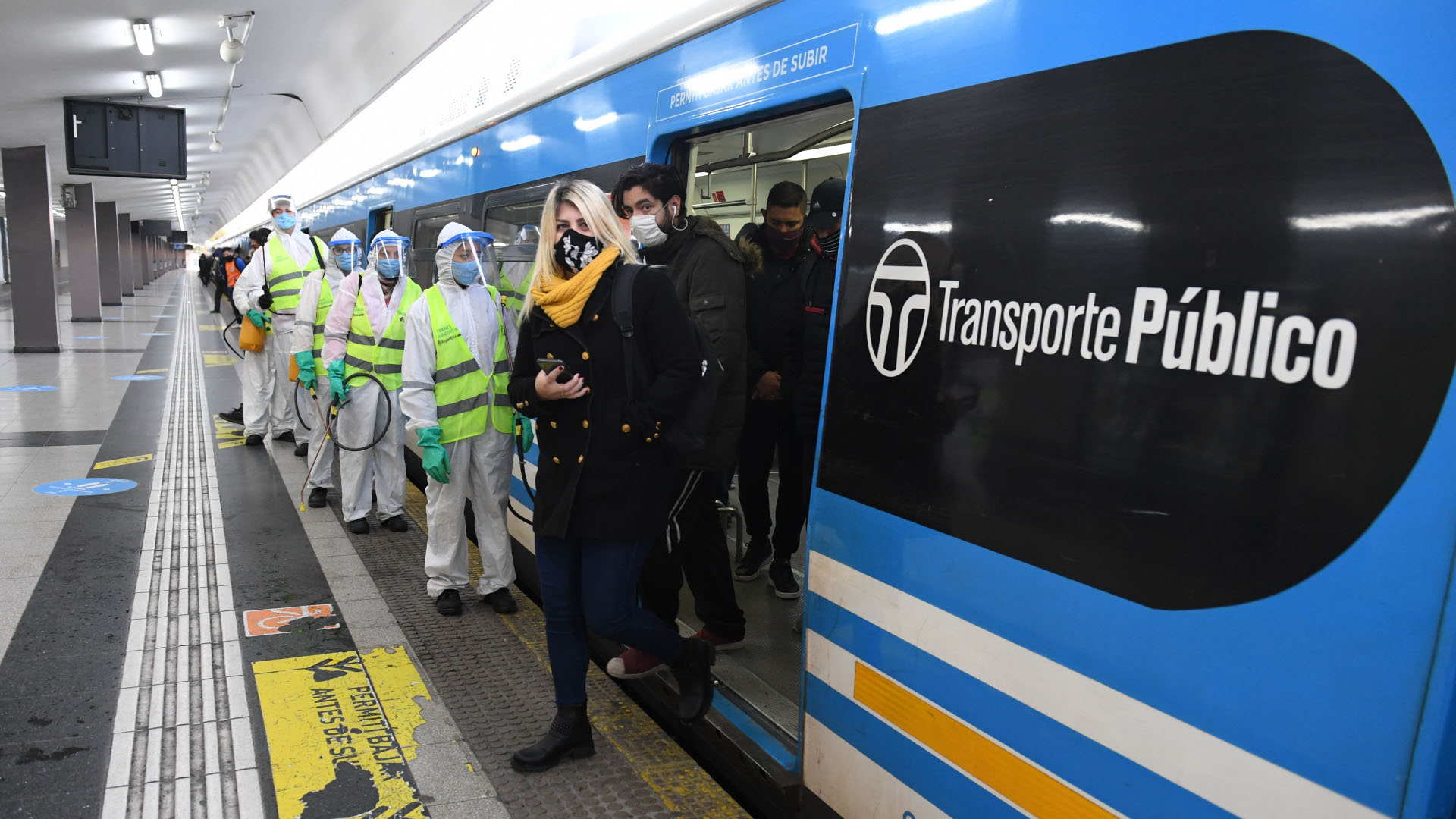 Empleados de limpieza aguardan en el andén a la espera de que bajen todos los pasajeros para abordar una formación del tren Sarmiento en la estación Once