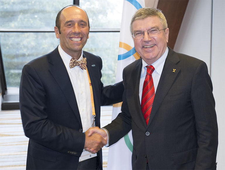 Fernando Aguerre con su moño de la suerte saluda a Thomas Bach, presidente del COI, principal ejecutor del ingreso del surf al olimpismo