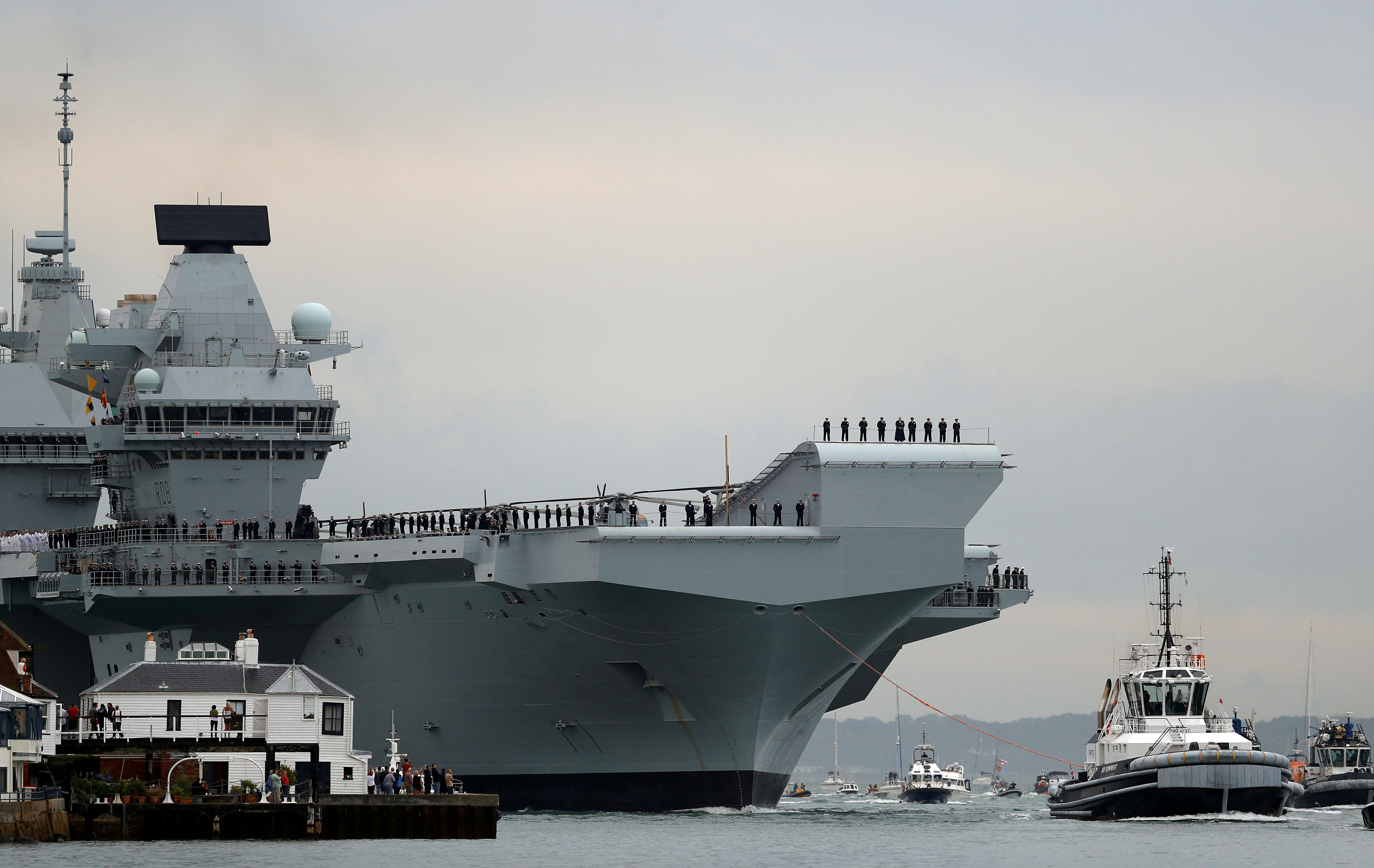 El portaaviones de la Royal Navy, HMS Queen Elizabeth, es remolcado por remolcadores cuando llega a la base naval de Portsmouth, Gran Bretaña, el 16 de agosto de 2017. (REUTERS / Peter Nicholls / Foto de archivo)