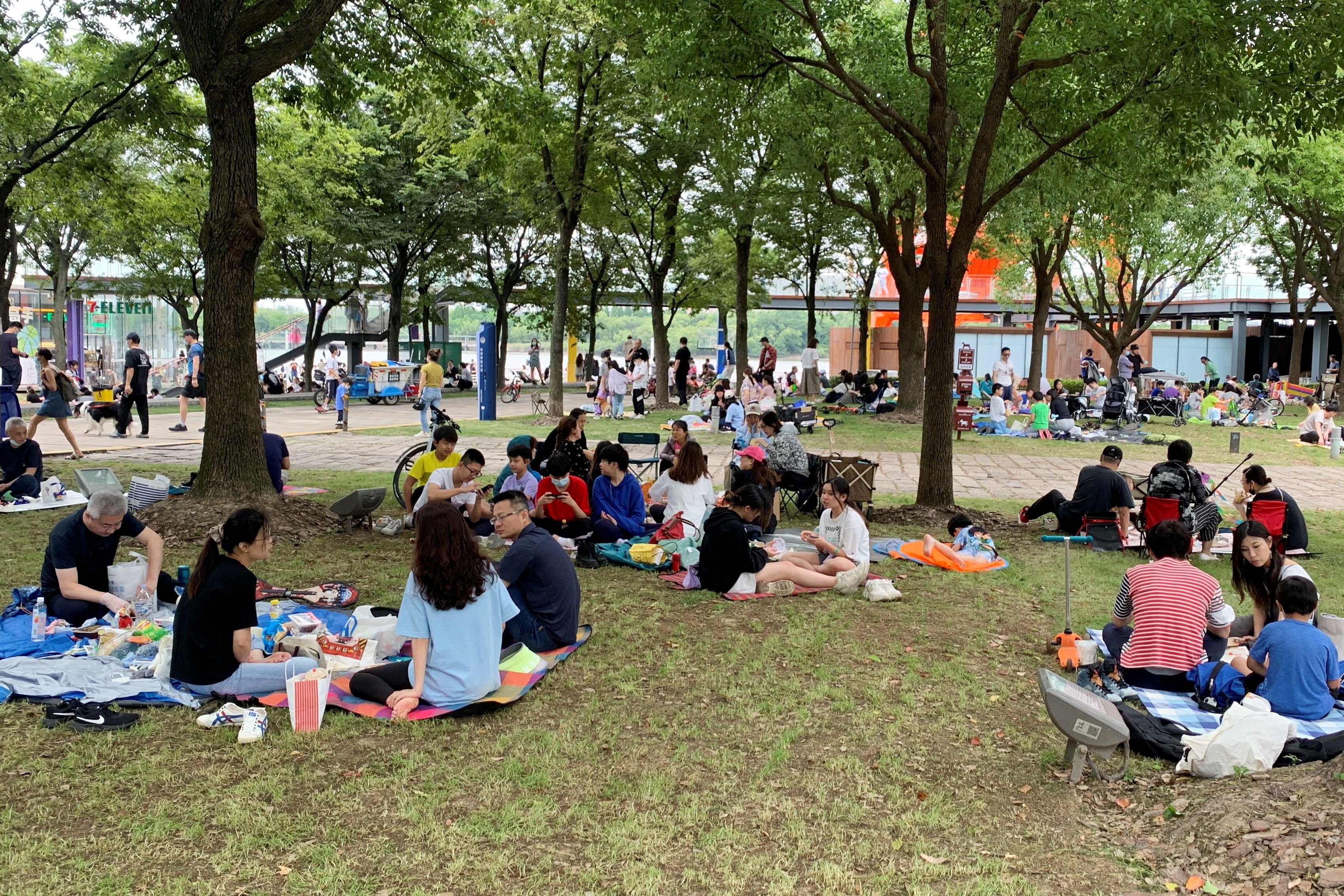 La gente hace un picnic al aire libre junto a un río durante el Dragon Boat Festival, el primer día festivo en la ciudad desde que se levantó el bloqueo por el brote de la enfermedad coronavirus (COVID-19), en Shanghái, China, el 3 de junio de 2022. REUTERS/Xihao Jiang SIN REVENTA . SIN ARCHIVOS.
