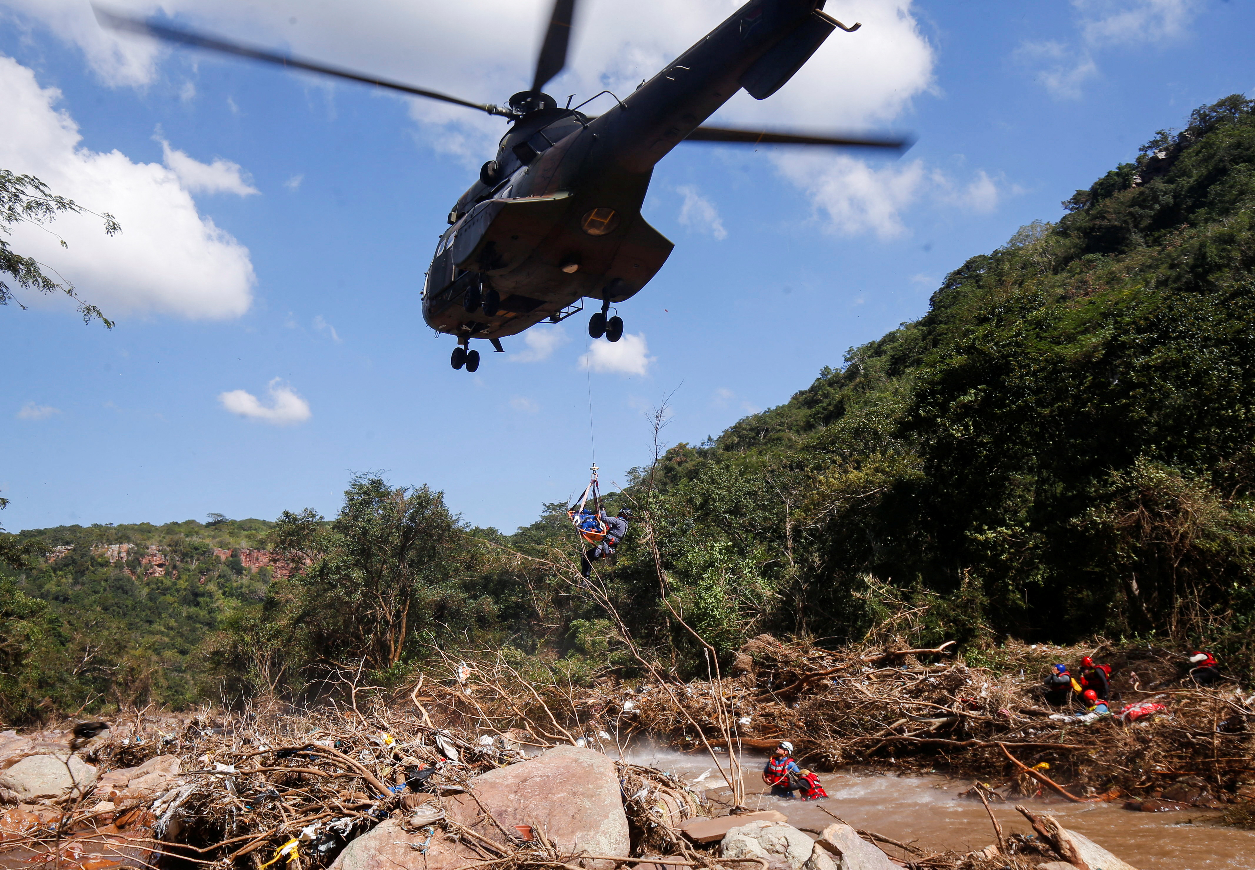 Un miembro de un equipo de búsqueda y rescate saca por aire un cuerpo del río Mzinyathi, cerca de Durban (REUTERS/Rogan Ward)
