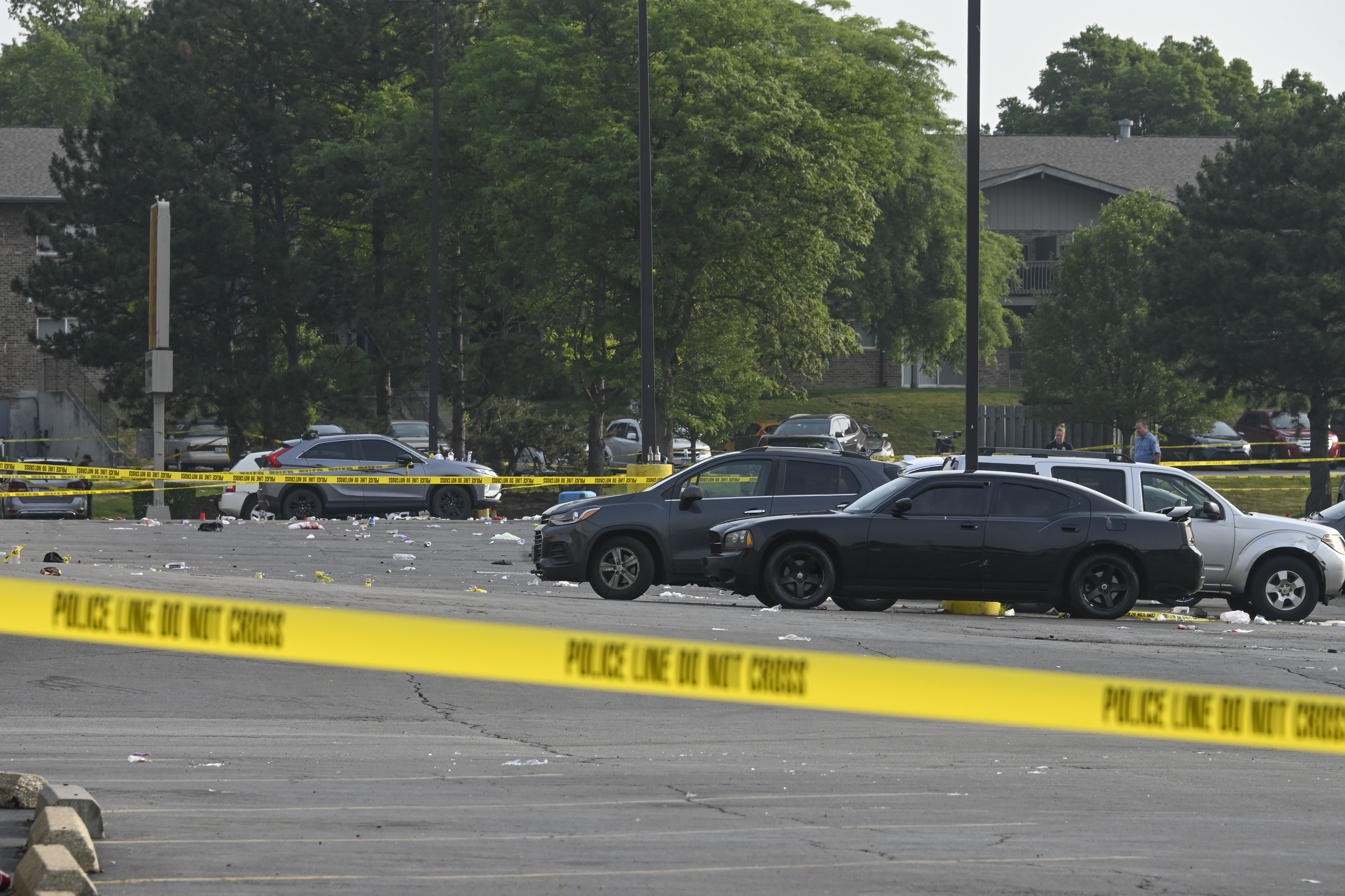 Investigadores observan la escena de un tiroteo masivo nocturno en un centro comercial en Willowbrook, Illinois, el domingo 18 de junio de 2023. (AP Foto/Matt Marton)