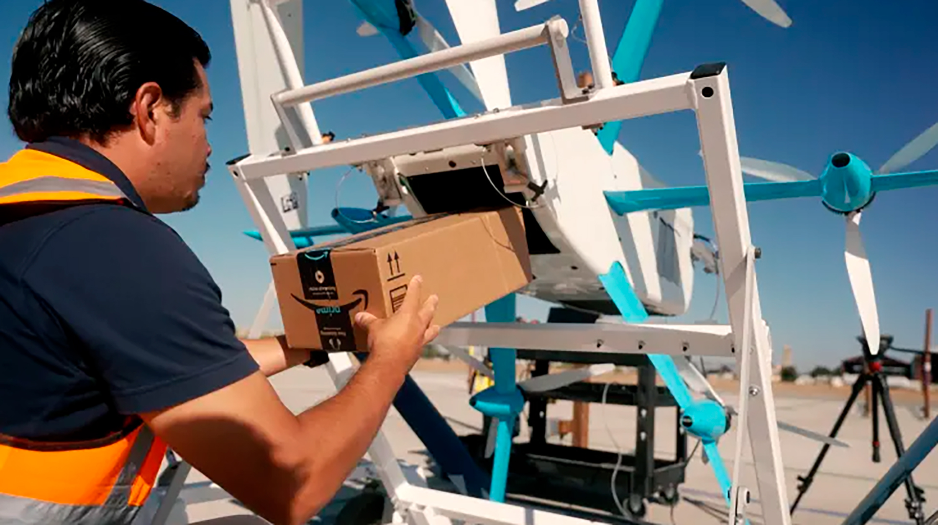 Amazon droneoperatør laster en boks inn i MK27-2 dronen (Amazon)