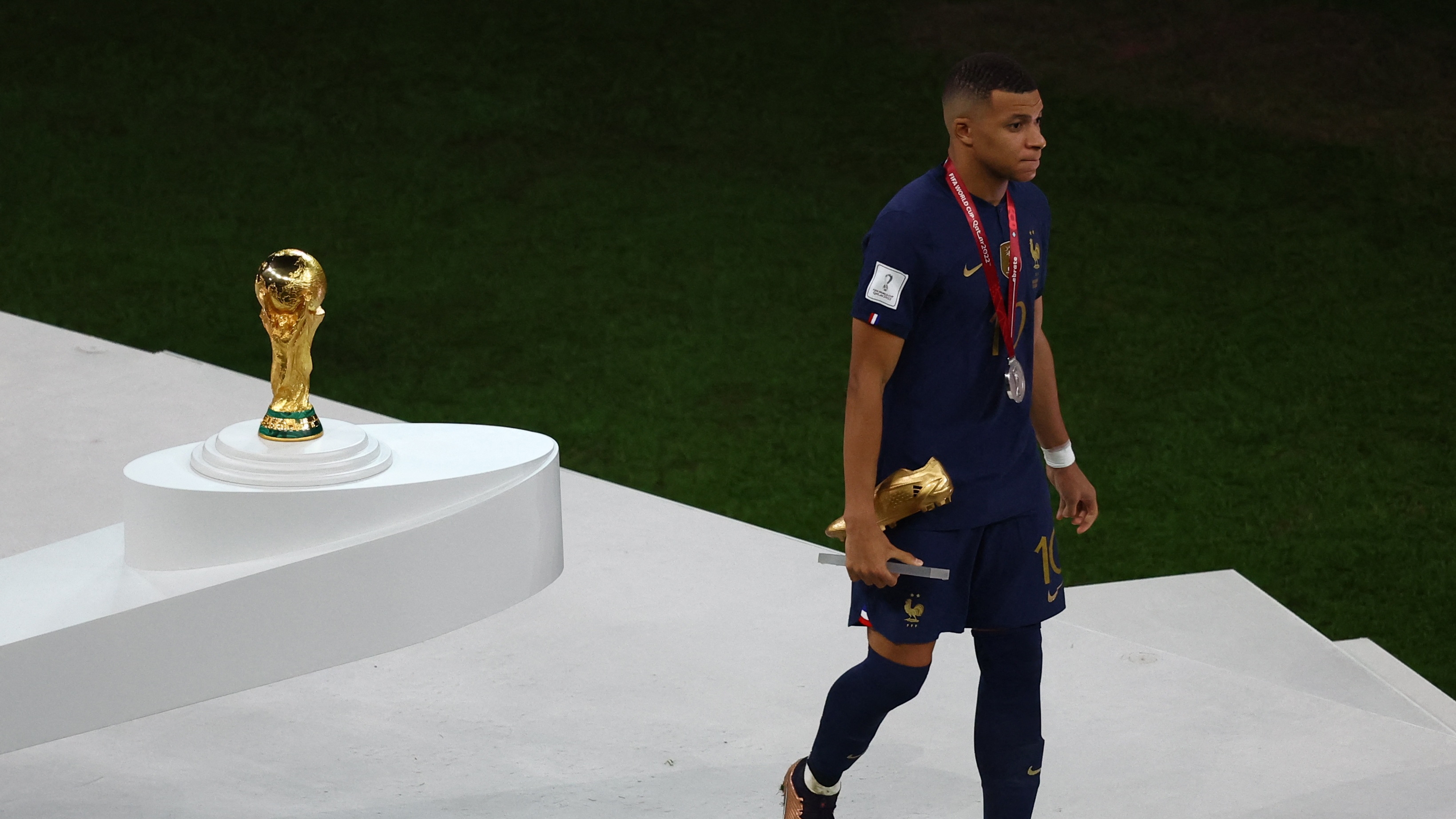 Soccer Football - FIFA World Cup Qatar 2022 - Final - Argentina v France - Lusail Stadium, Lusail, Qatar - December 18, 2022 France's Kylian Mbappe  holds the Golden Boot award as he walks after receiving the silver medal REUTERS/Paul Childs