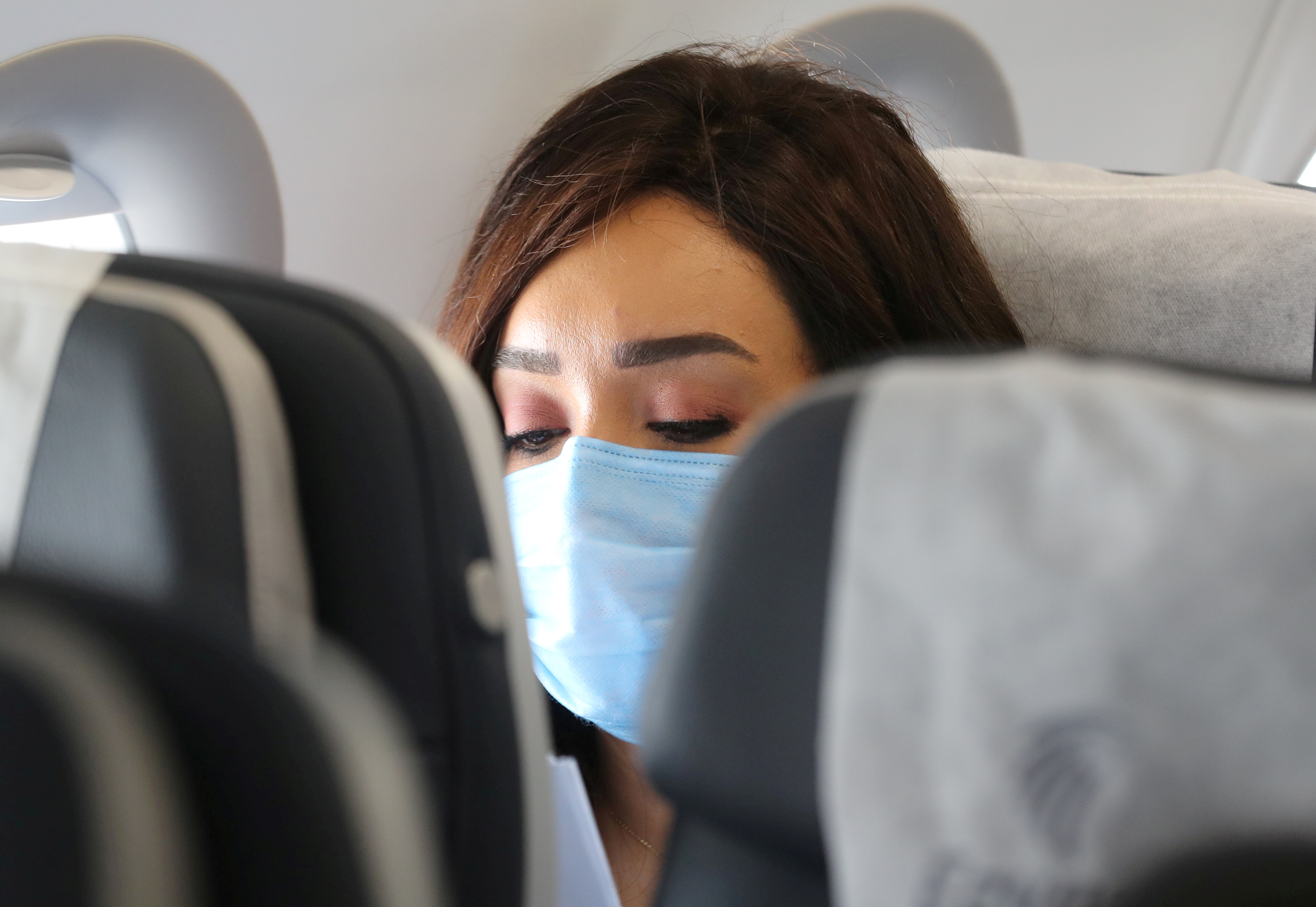 FILE PHOTO: A traveller wears a protective face mask on a plane, following an outbreak of the coronavirus disease (COVID-19), at Cairo International Airport in Cairo, Egypt, June 18, 2020. REUTERS/Mohamed Abd El Ghany/File Photo