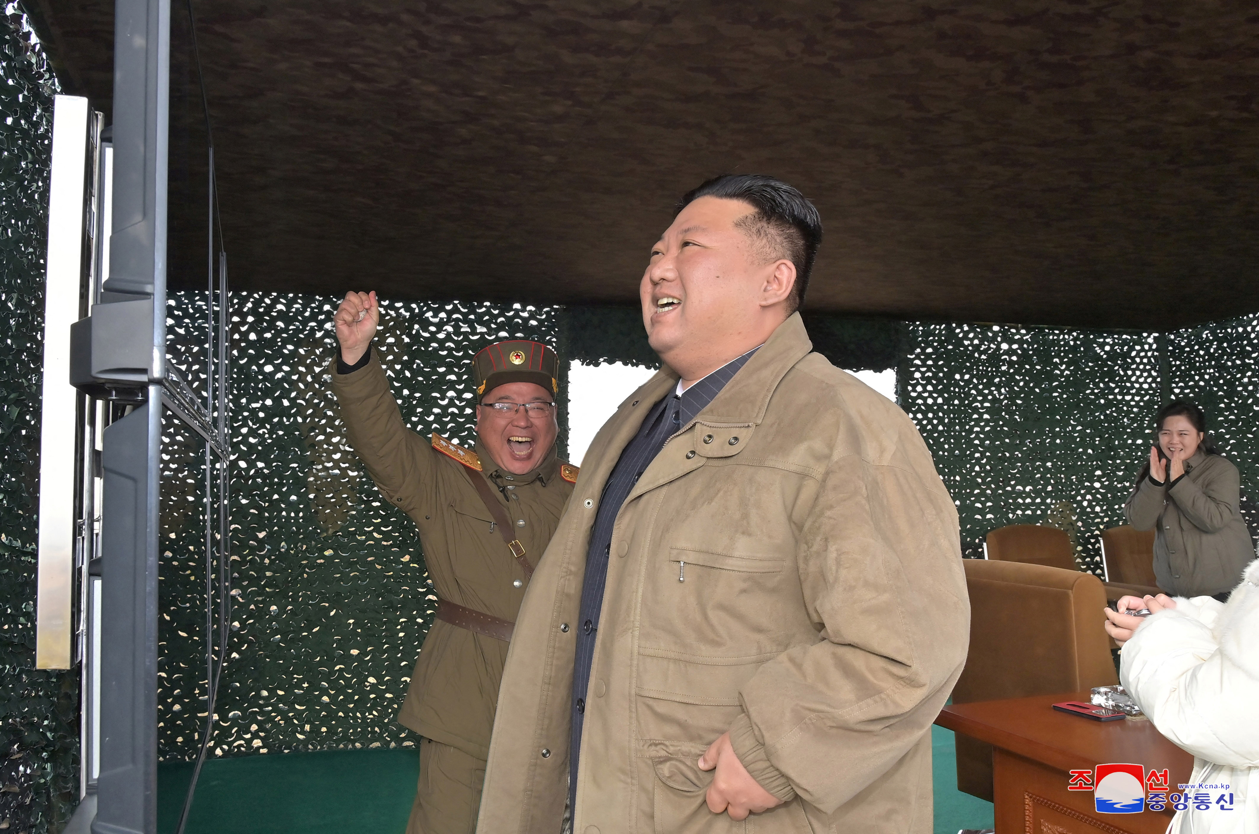 El líder norcoreano, Kim Jong Un, con su esposa Ri Sol Ju al fondo, reacciona el día del lanzamiento de un misil balístico intercontinental (KCNA via REUTERS)