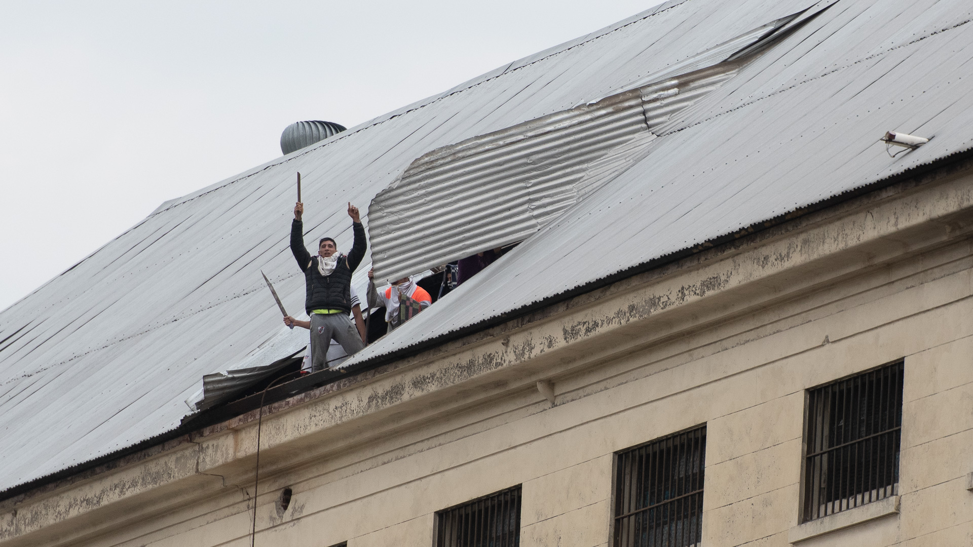Palo en mano, uno de los detenidos a cara descubierta se muestra.