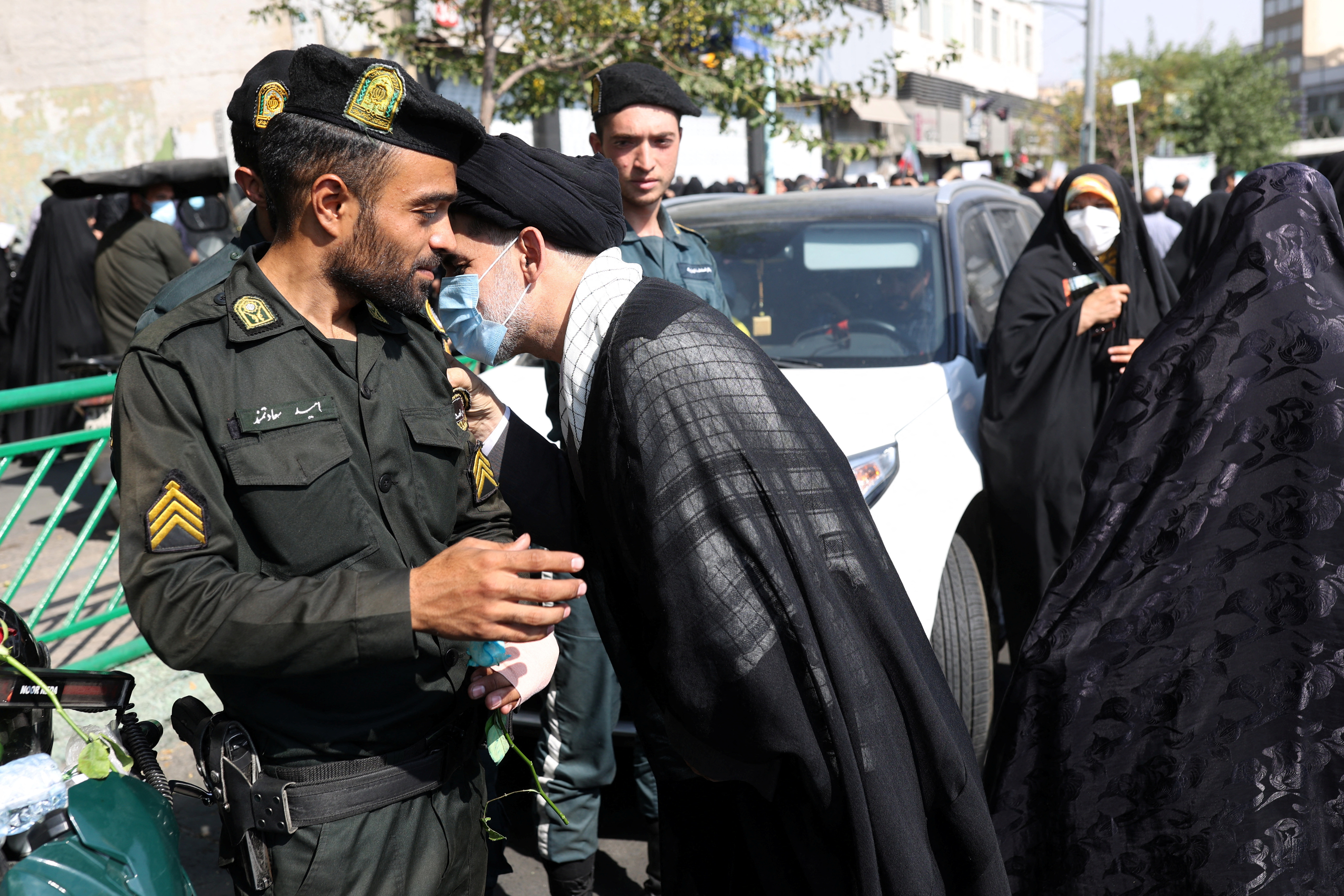 Un clérigo pro-régimen abraza a un policía en una manifestación a favor de las autoridades (WANA/Reuters)