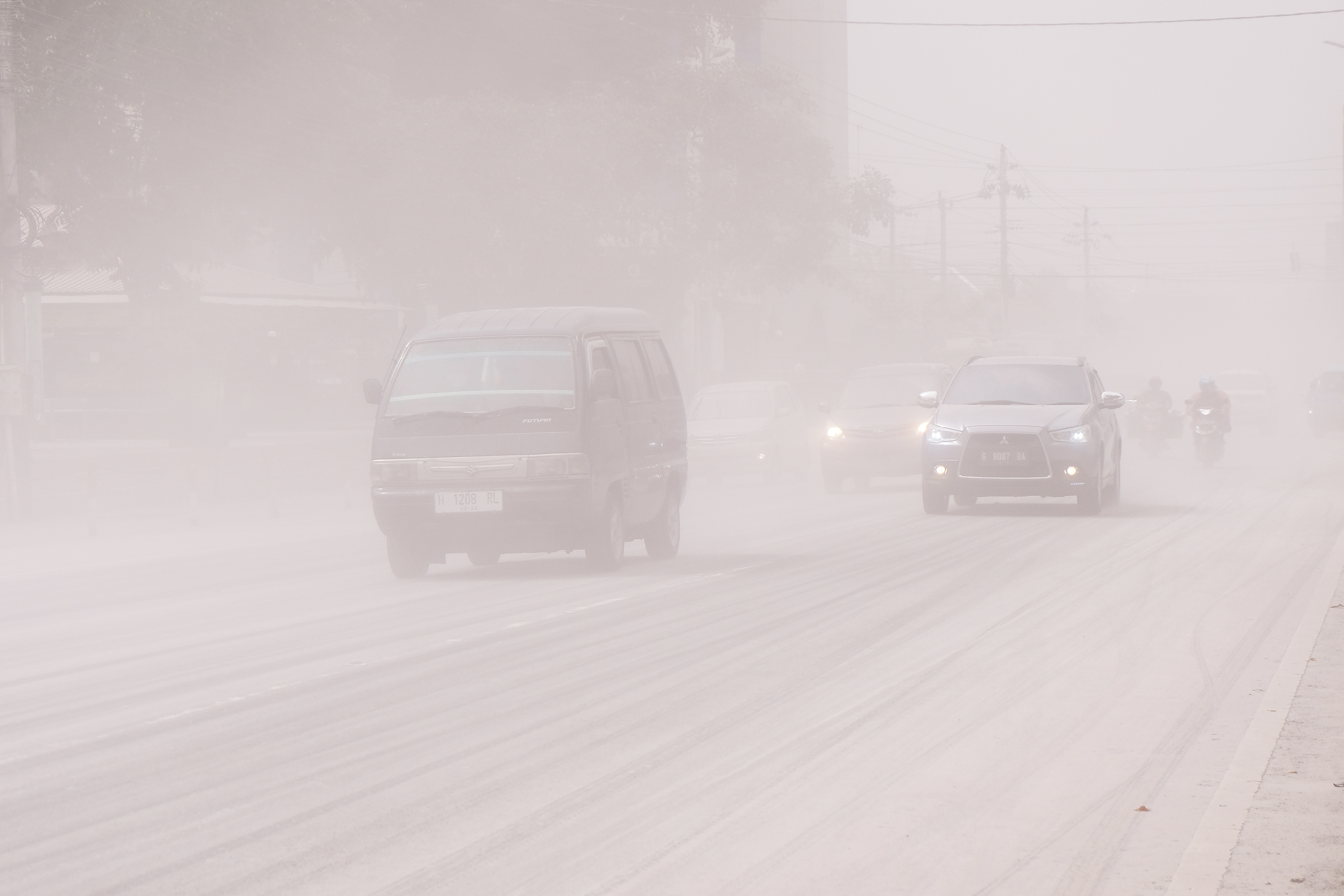 Coches circulan por una carretera cubierta de ceniza de la erupción del volcán indonesio Monte Merapi, en Magelang, provincia de Java Central, Indonesia, 11 de marzo de 2023. Antara Foto/Anis Efizudin/via REUTERS 