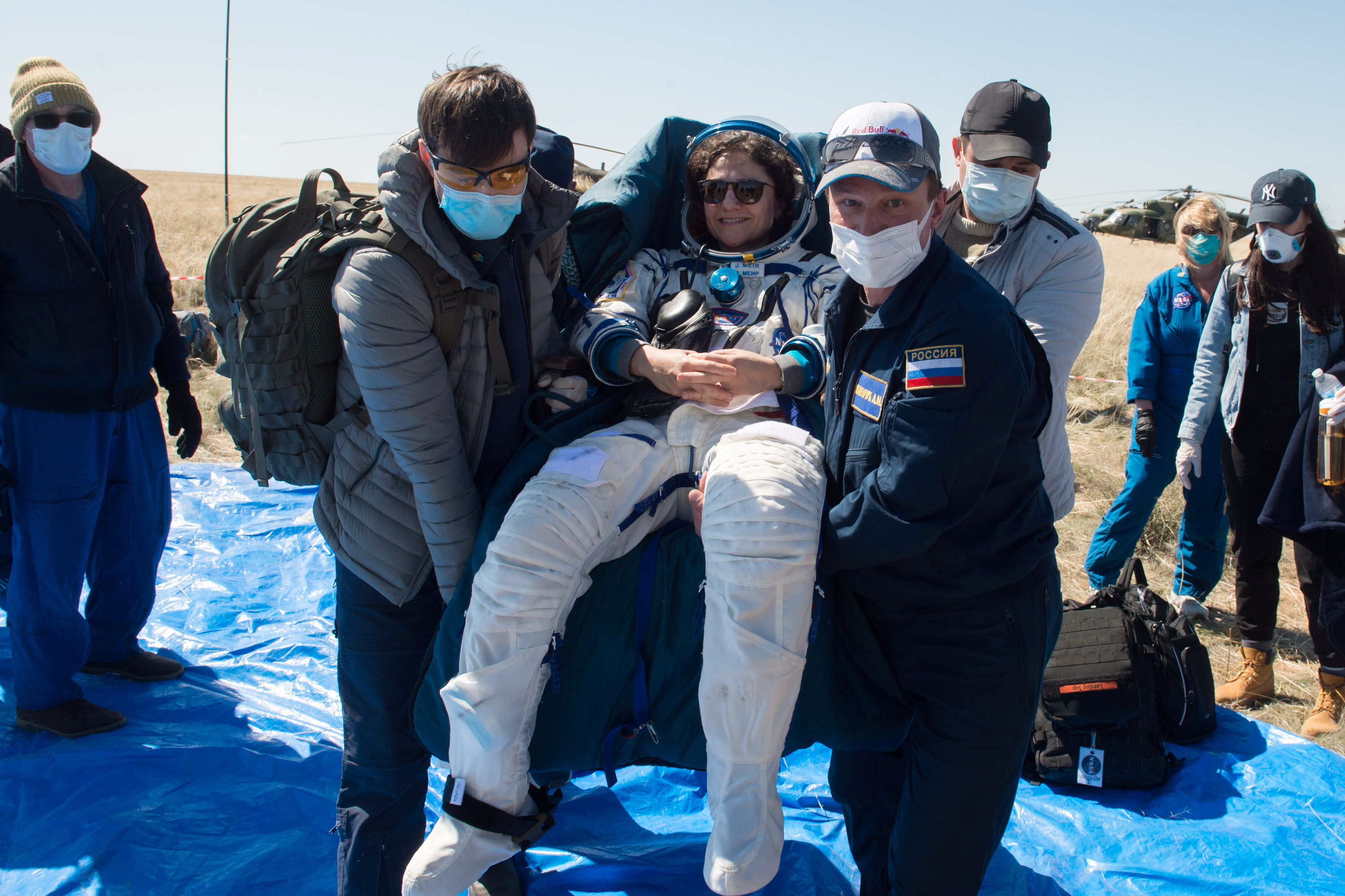 Personal de tierra lleva a la tripulante de la Estación Espace Internacional (ISS) Jessica Meir, de la NASA, tras el aterrizaje de la cápsula espacial Soyuz MS-15 en una zona remota a las afueras de Kazajistán el 17 de abril de 2020 (REUTERS) )