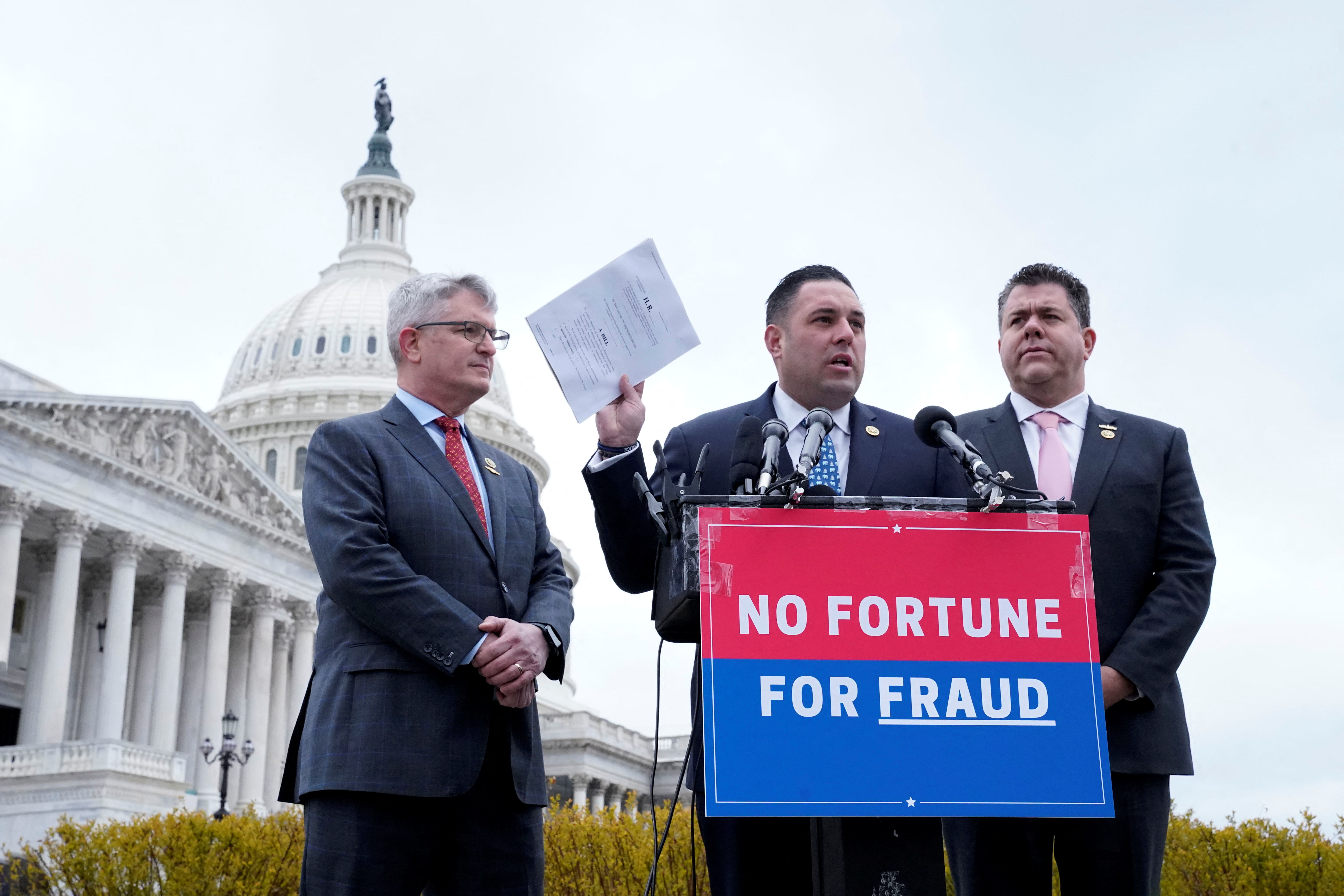 Rep. Brandon Williams (R-NY) and Rep. Nicholas LaLota (R-NY) look on as Rep. Anthony D’Esposito (R-NY) holds a copy of the "No Fortune for Fraud" Act, a law prohibiting House lawmakers convicted of certain offenses from profiting off their fabrications, during a press conference on Capitol Hill in Washington, U.S., March 7, 2023. REUTERS/Bonnie Cash