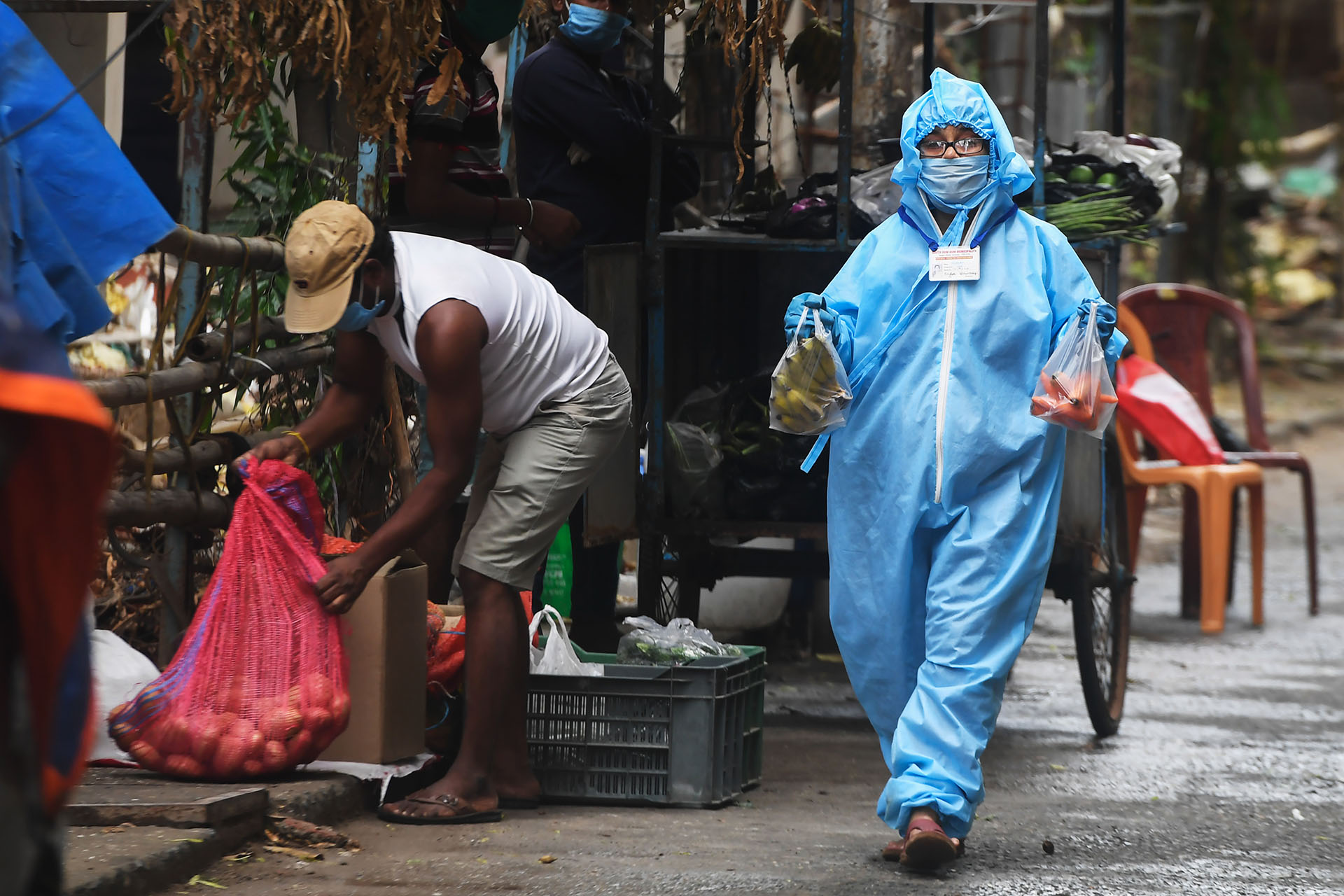 Tulika Roy, una trabajadora municipal, camina para entregar verduras de un vendedor a los residentes de una zona restringida con casos de COVID en Calcuta el 21 de abril de 2020. (Foto de Dibyangshu SARKAR / AFP)