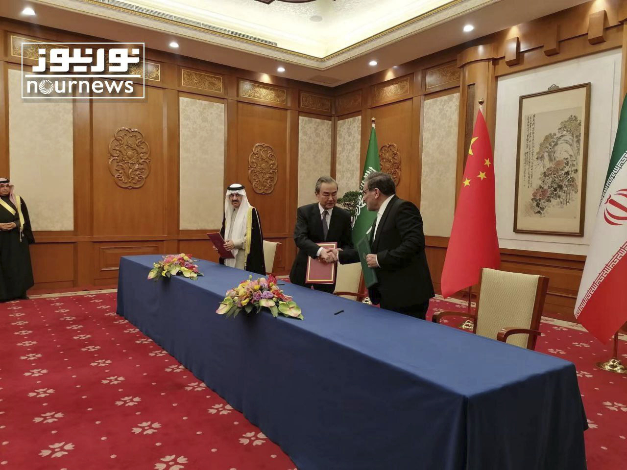 In a photo released by Nournews, Secretary of Iran's Supreme National Security Council Ali Shamkhani, right, greets Wang Yi, China's top diplomat, as Saudi national security adviser Musaad bin Mohammed looks on. al-Aiban, during a ceremony for the signing of an agreement between Iran and Saudi Arabia to restore diplomatic relations and reopen embassies after seven years of tensions, in Beijing, China, Friday, March 10, 2023. (Nournews via AP)