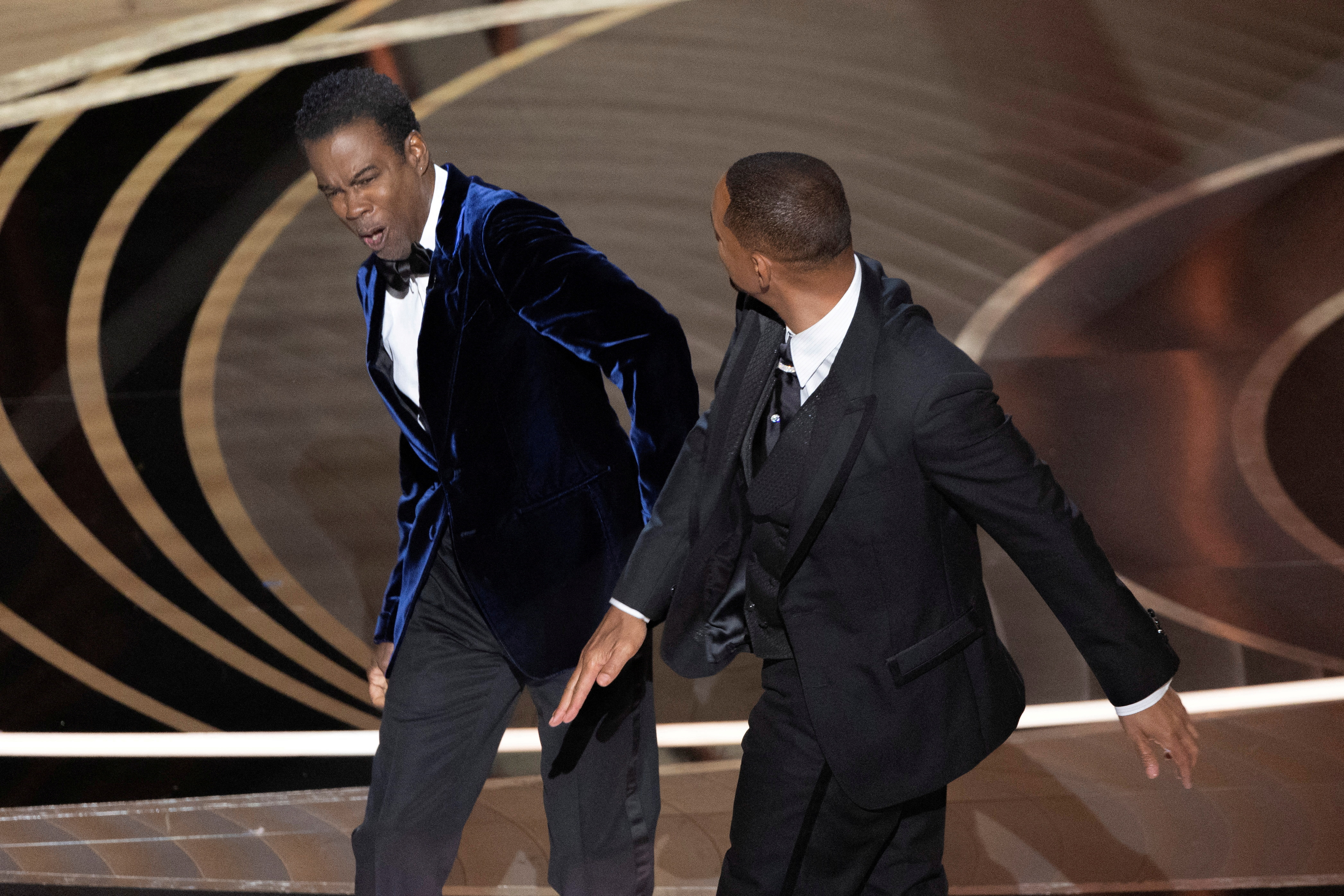 FILE PHOTO: Will Smith (R) hits Chris Rock as Rock spoke on stage during the 94th Academy Awards in Hollywood, Los Angeles, California, U.S., March 27, 2022. Picture taken March 27, 2022. REUTERS/Brian Snyder/File Photo