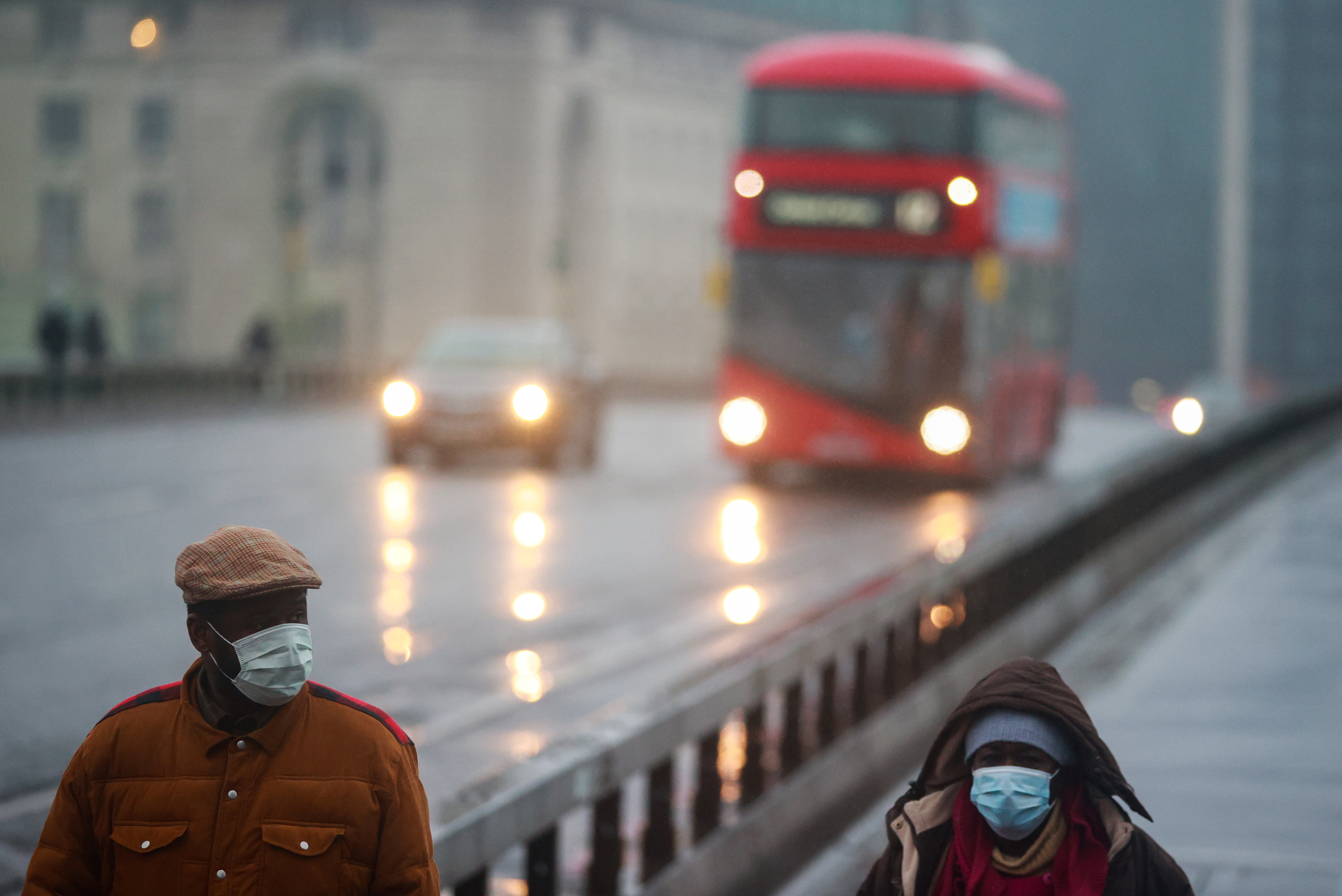 People wearing face masks walk across a near-empty Westminster Bridge, as the spread of the coronavirus disease (COVID-19) continues, Britain January 13, 2021. REUTERS/Hannah McKay