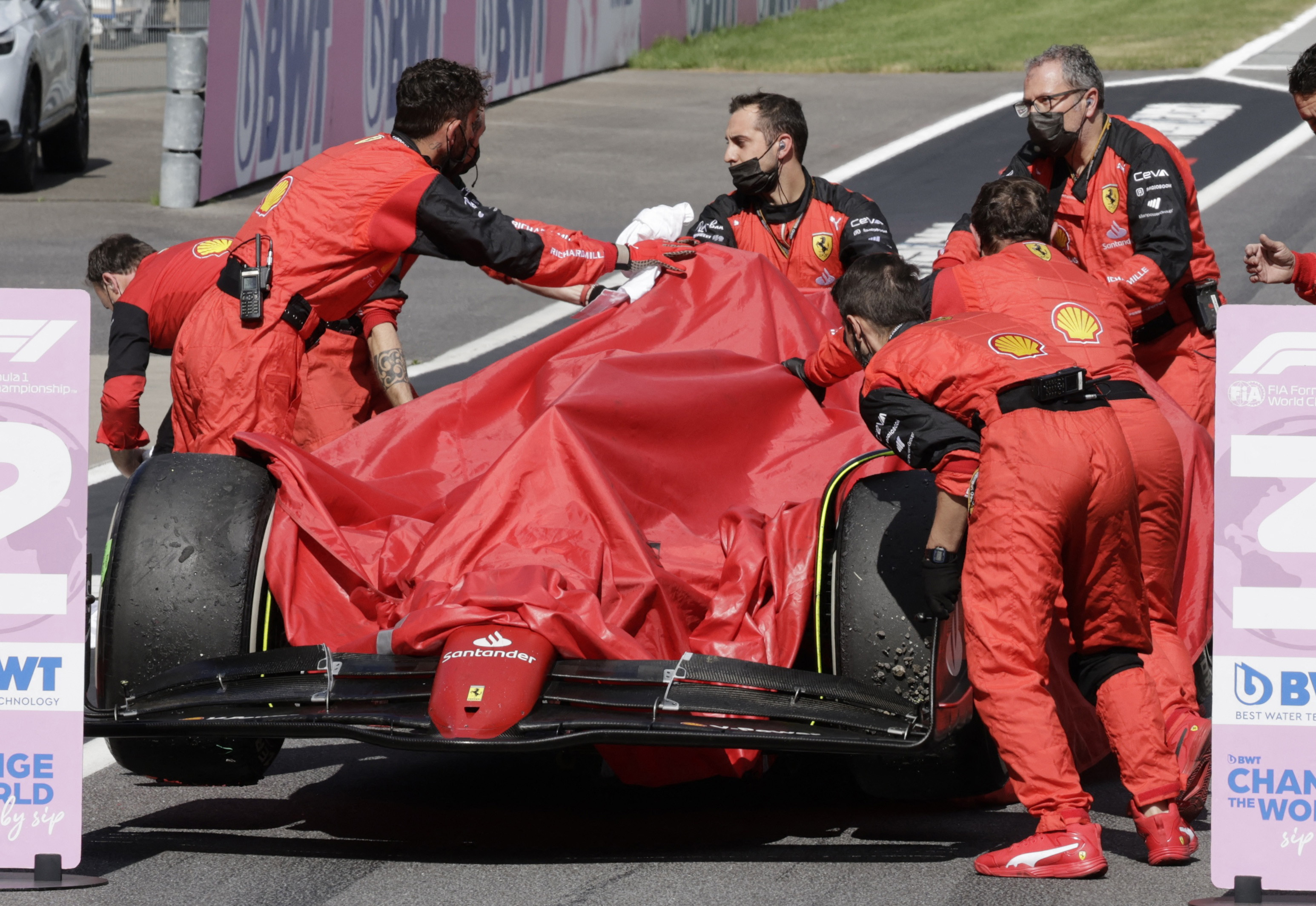 Los mecánicos de Carlos Sainz llevan a los boxes el auto  (REUTERS/Leonhard Foeger)